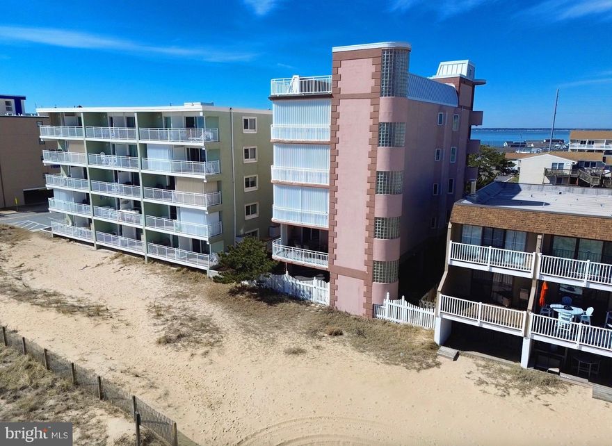 Discover a rare find on the Ocean City beachfront—an intimate four unit building offering privacy, space, and unbeatable ocean views. This 3 bedroom, 3 bath condo delivers 1,880 sq. ft. of coastal comfort, plus two assigned parking spaces and two additional guest spots. From the moment you arrive, the experience feels exclusive: enter through the west side exterior stairs or ride the keyed private elevator straight to your own lobby and front door. Inside, the layout is bright, open, and designed for easy beach living. A guest bedroom sits just off the hall—furnished and ready to enjoy—with a custom closet featuring built ins for effortless organization . Across the hall, the sunny south guest suite offers a double slider to the west facing balcony, where you can soak up year round sunsets and warm winter light. This bedroom also includes its own full bath for added convenience. Continue down the hall to find a large coat closet and a  dedicated laundry area with full size Whirlpool appliances and open shelving. Then the home opens up into a dramatic living, dining, and kitchen space with 10 foot ceilings and plenty of room to entertain. The wet bar—with Corian countertops, wine cooler, sink, and generous cabinetry—sets the tone for gatherings, while the expansive kitchen offers KraftMaid cabinetry, Corian counters, a radiant cooktop, built in oven, and thoughtful storage upgrades like pull out shelves and a lazy Susan. The living area features a natural gas fireplace, built in shelving, and an LG TV with speakers already in place. From here, step into the spacious main bedroom, complete with access to the oceanfront balcony and abundant natural light. The ensuite bath includes a jetted tub, walk in shower, double sinks, a seated vanity area, and separate linen and clothing closets—your own private retreat by the sea . The building is also undergoing its routine exterior refresh—caulking, coating, and painting—part of a proactive maintenance schedule completed every 5–6 years by the owners and management team. Another special  feature of this building is the roof deck -- for sunning, relaxing and enjoying the sunsets and fireworks throughout town, especially Seacrets Bar and Restaurant on the bay side.  If you’re looking for a beachfront home that combines privacy, space, and stunning views with the ease of condo living, this one delivers it all.  The unit is being sold unfurnished. The buyers can keep what is in the unit photos or we can help get it removed. Seller is offering a 1 year American Home Warranty to buyers at closing.