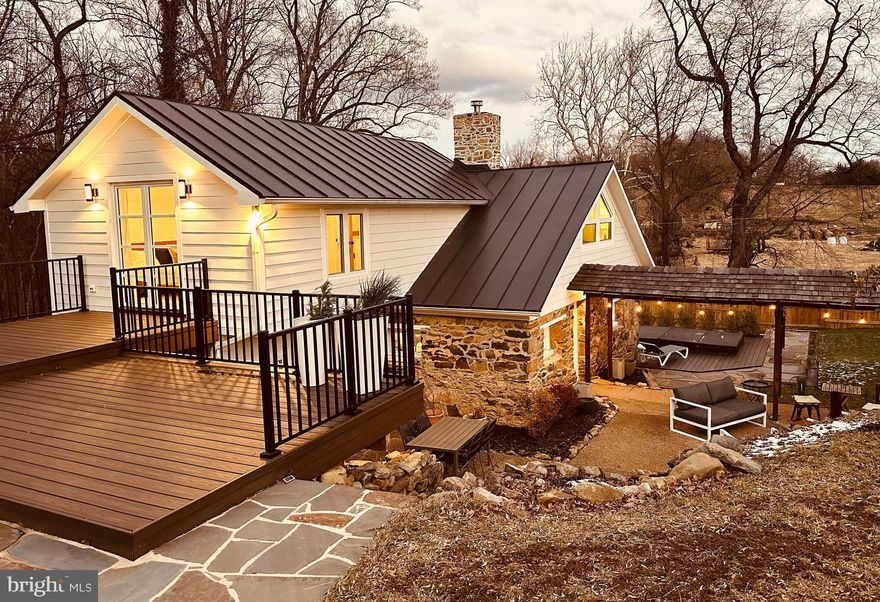 Own a piece of history nestled in the prestigious Stoneleigh Golf and Country Club Community, on the 17th hole. This beautiful stone cottage, Circa 1750, was taken down to the studs and brought back to life with modern, custom renovations. This home is a little piece of heaven, complete with privacy, nature, and luxury.
The main house sits on 1.5 acres and boasts 3 bedrooms, 2 baths, and a walk-out finished basement, that includes a room with original stone walls and wood ceiling beams.  The home features all new German-engineered, 3 pane Tilt & Turn Windows and Doors, hardwood flooring throughout the main house, a water softener, water filtration system, and tankless hot water heaters. Outside, a 15ft x 8 ft H2X Master 15D Swim Spa was purchased in 2021, perfect for swimming, water exercise, lounging and hot tubbing, cool temperatures for summer and hot temperatures for winter.
Outside, head through the breezeway to see the detached 2 car finished garage/barn with storage above. An additional 28'x42' 3 car detached garage, is separately metered, built in 2022, with a half bath on the main level, HVAC, washer and dryer, plus a 1200 sqft apartment above, with a full bath, kitchenette, a generous bedroom with a walk-in closet and large hobby room.
Come to relax, enjoy the peace and quiet, with all the modern comforts and finishes. Everything has been done, new plumbing, wiring, insulation, flooring, drywall, fixtures, interior doors.  New asphalt driveway in 2022, New Trex Decks in 2023. Main house metal roof and HVAC in 2017. A true one of a kind, with endless character, gorgeous finishes, custom features, amazing outdoor living space, tucked in the back corner of the most perfect neighborhood in Loudoun County! Come call Stoneleigh home. Agent/Owner Property