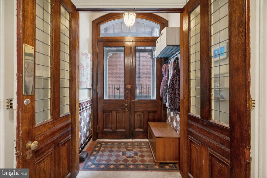 Welcome to this stunning Victorian mansion, impeccably updated with modern amenities while preserving its historic charm. With soaring ceilings and oversized windows throughout, this 3-story home boasts 5 spacious and airy bedrooms, 4.5 bathrooms, plus a large den/office. As you pass through the original wrought iron gates you are greeted by a historically restored porch.  Enter through double doors into the center foyer, with 12' soaring ceilings and sweeping staircase. The grand formal living room features gorgeous inlaid hardwood floors, elaborate crown molding, fireplace, chandelier, stained glass windows, and many original architectural details. The spacious eat-in kitchen is a chef's dream with high-end appliances, large marble island, exposed brick walls, slate counters and floor to ceiling custom cabinetry.  On this floor you'll also find a fully functioning second kitchen, currently being used as a mudroom or catering kitchen, but could easily serve as the second kitchen if converted back to a multifamily home.  Upstairs you'll find three stately bedrooms, one currently used as a den/office with laundry and another being used as a family/playroom, along with two tastefully decorated bathrooms. Continuing to the third floor, you will discover the majestic primary suite complete with a sitting and dressing area and ample closet space. The 5 piece primary bath is completely redone with a glass walk-in shower, double vanities and modern soaking tub. Two additional bedrooms and a full bath complete the third floor.  Outside the home is your own secret garden, a huge backyard landscaped with mature trees, flowers, and multiple seating and dining areas creating a serene and peaceful retreat. This home is located in the desirable Fairmount neighborhood and Bache-Martin Catchment and close to an array of dining and shopping options. With its timeless beauty and rich history, you will not want to miss the grandeur and charm of this remarkable home.