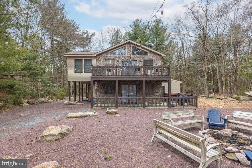 Expansive stone-front Pocono vacation home nestled in popular Lake Harmony Estates with access to it's own private community beach, tennis courts, rare Power boat Lake Harmony, as well as Jack Frost and Big Boulder slopes! This perfect investment property is ideal for guests, boasting 7 bedrooms including 2 primary suites, 4 baths, 6-8 car parking, huge firepit for roasting marshmallows, and lush yard with pretty outdoor lighting, rare central air, an oversized trex deck, and large hot tub! The sundrenched great room boasts gleaming hardwood floors, dramatic stone fireplace, cathedral vaulted ceilings with knotty pine, stunning wall of windows, and bright sliders to the Trex deck. The gourmet kitchen features granite countertops and island, stainless steel appliances, wine fridge, recessed lighting, and opens to a large dining area. The expansive family room features a game room/media room with wet bar/ kitchenette that can be easily used as an in-law suite, wide-plank LVP flooring, and propane stone fireplace! The two primary suites on each level have huge closets, plush carpeting, and their own full bathrooms. The additional bedrooms are also spacious, with large closets, wall-to-wall carpets, and neutral paint. The four season sunroom can also be used as a bedroom or library. Plenty to do at the Pocono Raceway, Camelback, Camelbeach, Split Rock's indoor waterpark, Kalahari, Mt Airy Casino, Pocono Premium Outlets, Hickory Run State Park, golfing & whitewater rafting in Jim Thorpe! Approx 210K income. (165K on platforms plus private bookings).