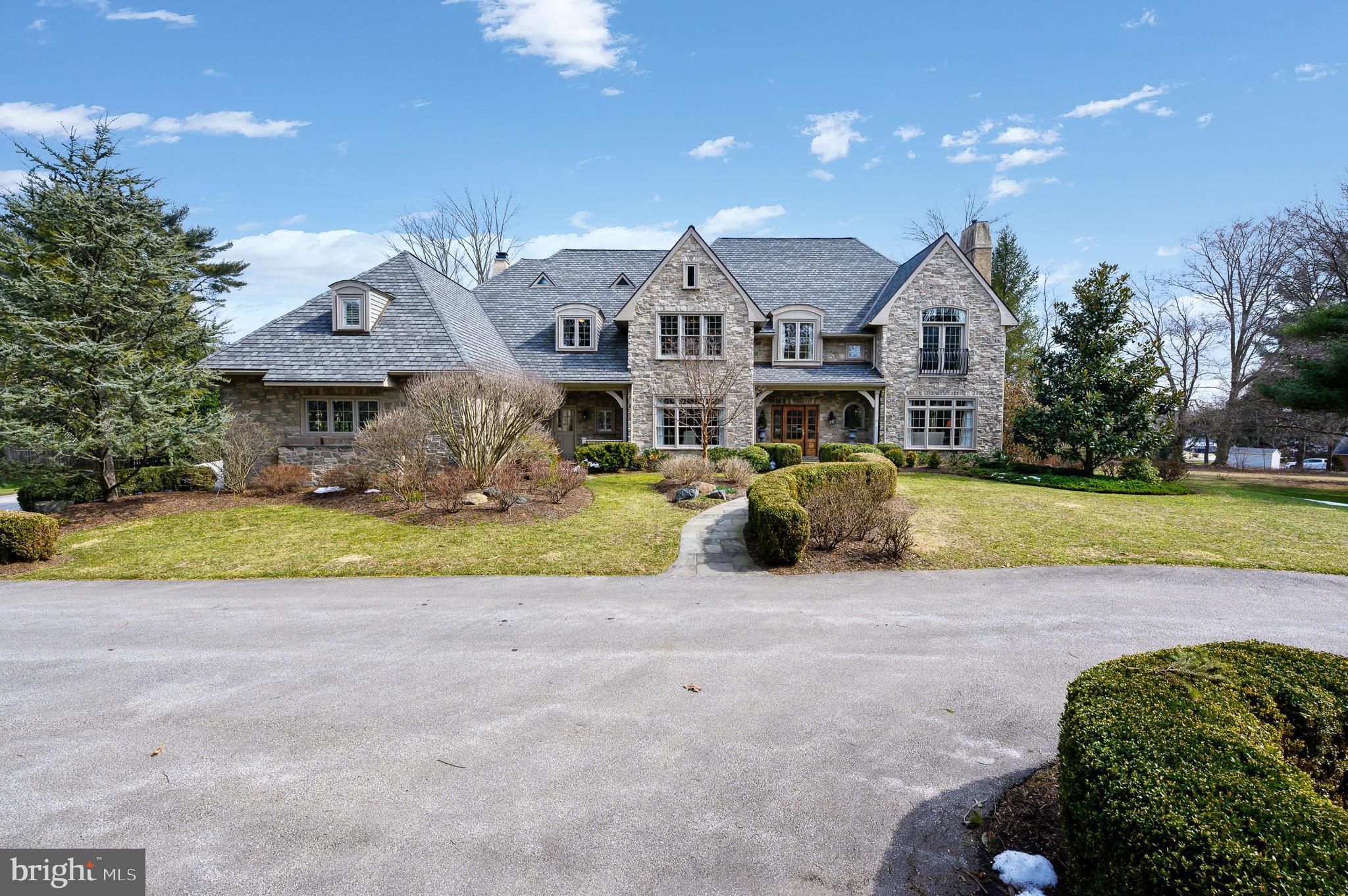 Welcome to this elegant 3 story English Manor unique estate in an incredible location! This home sits on over an acre in Haverford. With 5-6 bedrooms, 6 full and 2 half baths, over 8800 square feet of living space plus an unfinished attic space offering an additional 2000+ square feet waiting to be finished! Built in 2005 by Wayne Geftman, the attention to detail is striking. Arrive through a circular driveway with generous parking for guests as well as a 3 car garage. The roof lines and windows enhance the architectural details as you approach the manse. Enter into the large entrance hall with a grand staircase and plenty of natural light. An arched doorway leads to the bright formal living room with views of the property. There is a home office adjacent to the living room with built-in shelving and cabinetry. The formal dining room has a rich gold ceiling and molding detail with French doors to the butler’s pantry with sink, display cabinetry and a wine cooler for ease of entertaining. The white chef's kitchen has a contrasting island with shelving, cabinets and seating. Gas Wolf cooktop, Sub-Zero refrigerator and double ovens make meal preparation a pleasure. The kitchen opens to a bright sunroom as well as a fireside family room with a built-in projector screen. The mudroom, side entrance area has back stairs that lead all the way to the unfinished 3rd floor. The en-suite main bedroom, on the second floor has his and hers closets, dressing area, sitting room with shelving, large bath with soaking tub and walk-in shower and a private water closet. There are 4 additional bedrooms and 3 additional baths on the second floor. Ed Mahoney designed the lower level that boasts hardwood floor throughout, a bar with sub zero fridge, ice maker and dishwasher, game room, exercise room, media room and a 1000 bottle wine tasting room as well as another potential bedroom and full bath. There is a 3 story elevator to allow easy access to all three floors. Enjoy your summers around the gorgeous pool area with a separate spa. The stunning pool house was also designed by Mahoney and is sumptuously appointed with a gas indoor/outdoor fireplace, open beamed ceilings, a kitchen, full bathroom, a full basement for storage and retractable bi-folding doors to make indoor outdoor entertaining a breeze! This manor home has every convenience to live many years in comfort and elegance with modern amenities!