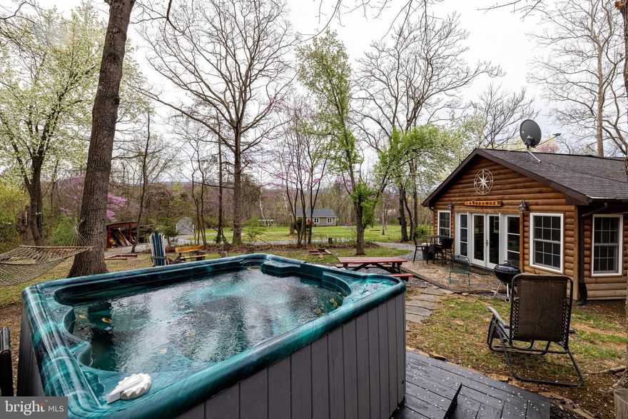 Welcome to Whitefish Cabin adjoining the George Washington National Forest and with its close proximity to the Shenandoah River and charming Town of Luray. Whitefish Cabin is a classic stone cabin which offers the perfect blend of rustic character and modern comfort. Situated on two separate lots combined for over 1.5 acres, with private community access to the Shenandoah River only 500 feet away, this 2-bedroom, 2-bathroom cabin is ideal for a full-time residence, second home, or a turn-key investment property. In fact Whitefish Cabin is already operating as a successful vacation rental (STR), with the potential to build an additional rental unit on the extra lot included in the sale — or to simply enjoy the added privacy / acreage.  Inside the cabin you will find two inviting living areas, LVP flooring, butcher block countertops, a cozy wood-burning fireplace, and a bright sunroom that allows you to truly enjoy the beauty of all four seasons. Additional perks include a washer and dryer, and that most inside and outside furnishings convey!  Valuable outbuildings, lean-tos, and a nearly new shed provide multiple storage options! Outside you can unwind in the hot tub, gather around the firepit, or spend your evenings relaxing on the covered porch in nature in the adjoining George Washington National Forest. Utilities are community water, a shared septic system with the adjoining cabin, with a recorded easement in place, and soil work has been completed by a licensed soil scientist on the extra lot included in the sale enabling another rental unit to be constructed in the future if desired. There is no active HOA! This is a rare opportunity to own a peaceful cabin retreat, with strong rental income potential, in one of the Shenandoah Valley’s most desirable locations. Adventure awaits you at Whitefish Cabin!