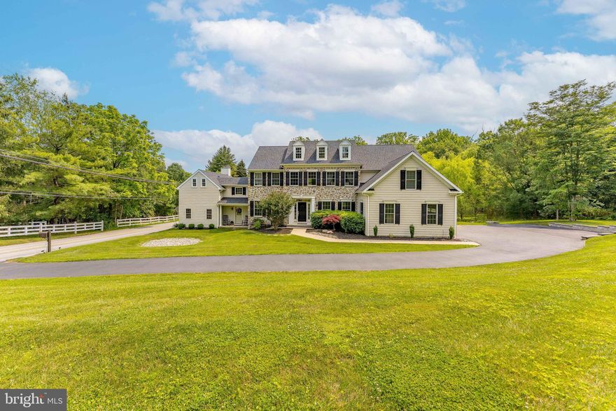 Welcome to 975 S Waterloo Road — a stunning 5-bedroom, 4.5-bathroom custom home set on a beautifully landscaped 1.4-acre lot in the prestigious Waterloo Mills neighborhood of Devon. Set on a picturesque lot, this exquisite residence showcases a blend of HardiePlank and stone exterior, and features a 3-car garage plus a large driveway. A charming breezeway connects the main home with a unique secondary living space, adding versatility to this expansive property. Step inside the grand foyer, where hardwood floors, a sweeping staircase with a chandelier, ceiling lighting, and a large walk-in coat closet set an elegant tone. To the left, French doors open into a bright living room with hardwood floors and front-facing windows. To the right, a formal dining room boasts hardwood flooring, a classic chandelier, and a direct connection to the heart of the home — the gourmet kitchen. Designed for culinary enthusiasts, the kitchen features granite countertops, stainless steel appliances, a spacious island with seating and pendant lighting, and a walk-in pantry. It flows seamlessly into a dramatic two-story breakfast room with balcony overlook, hardwood floors, and open sightlines to both the sunroom and family room. The sunroom offers a tranquil space with triple windows, semi-vaulted ceilings, and direct access to the private back patio and fenced yard. The family room features 9-foot ceilings, hardwood floors, and a gas fireplace — perfect for cozy evenings. A hallway off the kitchen leads to a powder room with pedestal sink, a mudroom with alarm system and side entrance, a laundry room, and a bonus room ideal for a playroom or home office. The breezeway brings you to a separate living area that includes a second living room with exposed wood beams, curved walls, a large wood-burning fireplace, and a closet. Continue on to the home theater, complete with berber carpeting, exposed beams, and elevated recliner seating — a dream for movie lovers. Above this wing, a private guest suite features a sitting room with hardwood floors, wood-beamed ceilings, and barn door to a full en-suite bath with semi-vaulted ceilings and single vanity. The adjacent bedroom includes wood floors, ceiling beams, and ample closet space. Back in the main residence, the second level includes a loft area with carpet and a balcony overlooking the foyer. The second and third bedrooms each offer carpet, ceiling fans, and share a Jack-and-Jill bathroom with tile floors, step-in shower, single vanity, and linen closet. The fourth bedroom includes carpet, a ceiling fan, and easy access to the full hall bath with a tiled tub/shower combo. The primary suite is a true retreat, offering carpet floors, a ceiling fan, a sitting area, and a custom walk-in closet by Closets by Design, complete with skylights and a built-in office nook. The luxurious en-suite bath features tile flooring, a soaking tub, walk-in tile shower with bench, double sink vanity with LED mirror, and a linen closet. Perfectly located near local shopping, restaurants, and grocery stores, this home also enjoys close proximity to Waynesborough Country Club, offering the best of Main Line living. Don’t miss your chance to own this exceptional property — a rare blend of luxury, functionality, and timeless charm!
