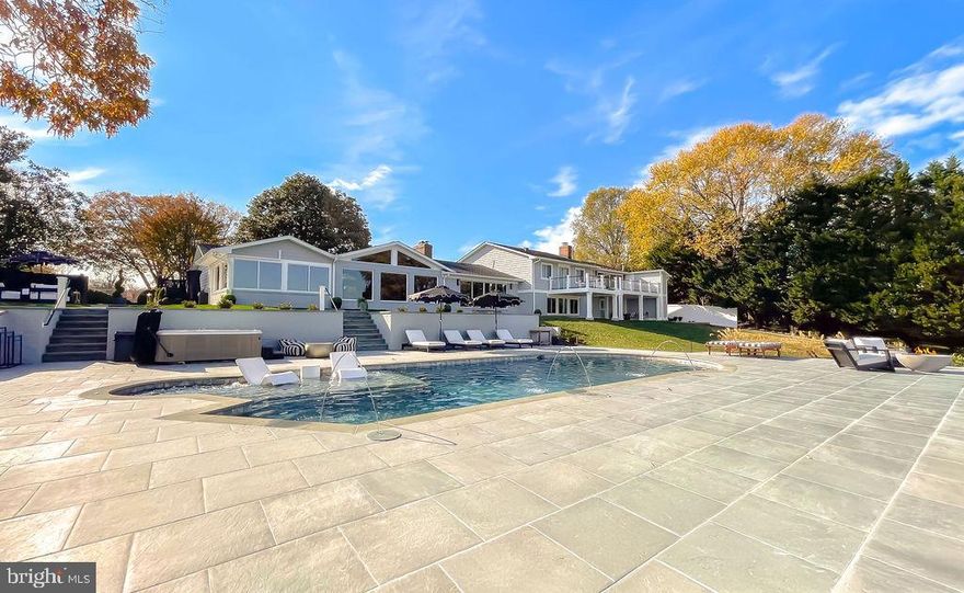 Bella Vista on the Patuxent River – An Elevated Waterfront Retreat

Nestled on the banks of the Patuxent River in Esperanza Farms, Bella Vista is a five-bedroom, five-and-a-half-bath waterfront retreat where intentional design meets resort-style living. Thoughtfully reimagined with a full interior renovation in 2023 and an exterior transformation in 2024, this multilevel home offers the rare advantage of a fully accessible main level—ideal for multigenerational living, aging in place, or welcoming loved ones with ease.

The main level features a thoughtfully designed, fully accessible primary suite with a curb-less, zero-threshold shower, designer grab bars, and a spacious layout that blends elevated design with universal comfort. This level allows for everyday living without stairs while maintaining the flexibility and privacy of a larger home. Four additional spa-inspired bedroom suites are located throughout the home, including waterfront bedrooms with automatic remote-control shades and a private suite featuring a fireplace and coffee bar with sink and beverage refrigerator.

At the heart of the home, the chef’s kitchen showcases high-end appliances, generous workspace, and a gas fireplace, flowing effortlessly into a welcoming living area anchored by its own gas fireplace. A light-filled all-season sunroom, private gym with sauna, custom entertainer’s closet, and an exceptional laundry room with two washers, two dryers, and a marble dog shower elevate everyday living. The garage adds a second dog and beach-day rinse station for ultimate convenience.

Outdoors, Bella Vista unfolds as a private waterfront resort: a heated saltwater pool with elevated hot tub, two exterior gas firepits, expansive patios for golden-hour gatherings, and a wood-burning fireplace for cozy evenings by the water. A private pier with Jet Ski lift offers direct access for kayaking and canoeing along the Patuxent River.

With a proven 5-star short-term rental history, turnkey design, and the option to purchase fully furnished, Bella Vista is more than a home—it’s a refined, move-in-ready experience, designed to be lived, shared, or enjoyed from the very first sunset.