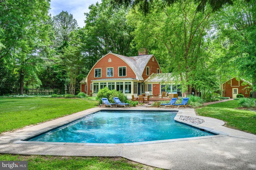 This architecturally charming waterfront home sits on 5.6-acres of well-elevated land that offers an exceptional secluded setting and panoramic, wide views of Broad Creek. Located just minutes from Historic St. Michaels, this lovely home was thoughtfully expanded by the Easton architectural firm, Atelier 11 in a way that honors its distinctive New England “Bow House” architectural style while updating the interior with high quality finishes and a thoughtful, functional floor plan. The first-floor waterside primary bedroom suite includes a library/office, a custom built-in wood paneled wardrobe/dresser wall and primary bathroom with a large glass-enclosed walk-in shower. The Laundry is conveniently located in an adjacent closet. The exceptional chef’s kitchen features a six-burner Wolf stove, a wood paneled Subzero refrigerator and Miele dishwasher. The granite counters offer plenty of prep space and the quality Mauser brand white shaker-style cabinets are quite beautiful. The large center island provides bar seating ideal for an entertaining environment. The adjacent family room offers a wall of windows to take in the exceptional water views and a Rumford brick fireplace with hewn walnut beam mantle that creates a cozy ambiance. There is a second woodburning fireplace in the adjacent den that features a wood planked beamed ceiling and built-in media cabinet. Another full bath on this level is located off the mud room that leads to the waterside deck. A separate dining room is adjacent to the entry foyer. The second level features three charming guest bedrooms and bath with soaking tub and enclosed shower. The tasteful interior features gorgeous wide-plank heart pine floors throughout the entire home, natural wood paneled doors and moldings. A detached three-car garage offers ample storage and there are two storage sheds, a fenced vegetable garden and a freshwater pond with a fountain/aerator. A partial basement and attics above the house and garage provide additional storage space. With 200 feet of riprapped shoreline, the property offers a recently built 6’ wide private dock with water, electric and 3’+ of MLW depth that is perfect for boating enthusiasts and waterfront living. The expansive grounds also feature a beautiful 20’ x 40’ waterside pool and an Ipe-wood deck where you can relax while enjoying the breathtaking, panoramic views of Broad Creek and the visiting Osprey and Bald Eagles. Come experience this enchanting property and serene setting that is just six miles from quaint Saint Michaels and its wonderful restaurants, shopping and amenities. ** Enjoy the virtual tour and floor plan by clicking on the movie camera icon!