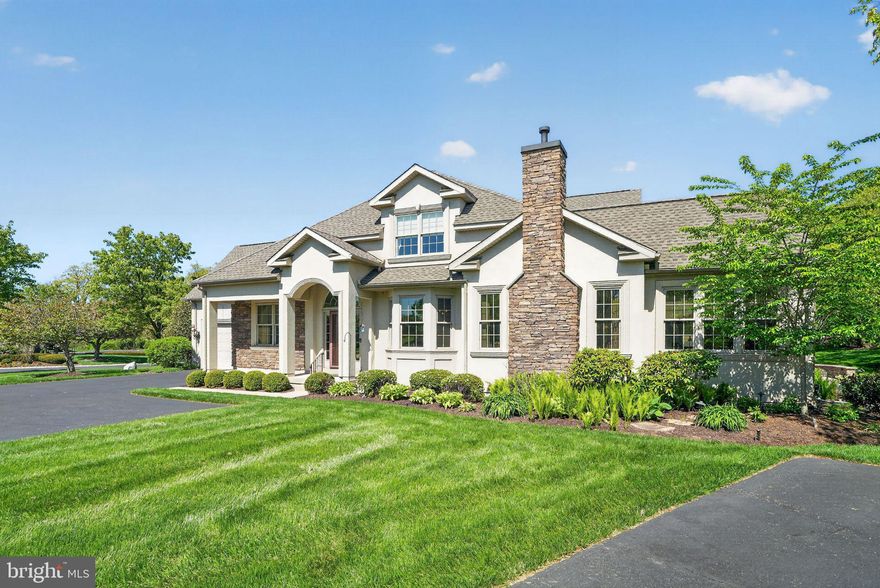 Wonderful, sought-after Indian Valley Greens, the premier 55+ community adjacent to the Indian Valley Country Club, renowned for its stunning golf course. sets the stage for 285 Country Club Drive.  From the moment you enter, this beautifully maintained end-unit carriage home makes a lasting impression with its dramatic two-story foyer, highlighted by a palladium window, elegant chandelier, detailed wainscoting, and rich cherry wide-plank hardwood flooring that flows throughout the first and second levels. Designed for both everyday living and upscale entertaining, the home offers a seamless blend of open spaces and refined finishes. Just off the foyer, a private library or sitting room with double glass doors, crown molding, recessed lighting, and built-in ceiling speakers provides the perfect work-from-home or relaxation space. The formal dining room is equally impressive, featuring a walk-in bay window, classic moldings, and timeless architectural details. At the heart of the home, the welcoming great room offers a cozy gas fireplace, built-in entertainment center with surround sound, and an inviting atmosphere for gathering. Natural light fills the stunning solarium, complete with a vaulted ceiling, palladium window, and ceiling fan—an ideal space to unwind. The expansive gourmet kitchen is thoughtfully designed with cherry cabinetry, granite countertops, ceramic tile backsplash, a center island with sink, and high-end stainless steel appliances, including a Fisher & Paykel double drawer dishwasher, 5-burner gas cooktop, and new double ovens. The adjoining breakfast area opens to a Trex deck and brick paver patio with retaining wall, creating a perfect indoor-outdoor flow. Convenience meets luxury with a custom elevator servicing all three levels. The main-level primary suite is a true retreat, featuring a spacious bedroom with tray ceiling and a spa-inspired bath complete with heated floors, double vanity, jetted soaking tub, frameless glass shower, and multiple closets, including a walk-in.  The convenient powder room boasts bead-boarding half wall.. The spacious laundry includes cabinetry, built-in ironing board plus washer and dryer.  Upstairs, a versatile loft area provides additional living space, along with two generously sized bedrooms, a full bath, and a large unfinished walk-in attic offering excellent storage or future expansion potential. The 1,400 sq ft finished lower level significantly expands the home’s functionality, featuring a large recreation area with surround sound, a dedicated office with built-in cabinetry, a fully equipped workshop with outside access, and additional finished storage space with a second refrigerator and freezer. A powder room and unfinished utility area with sump pump and alarm system complete this level. Additional highlights include approximately 3,025 square feet of living space, a stucco and stone exterior, new roof, 9-foot ceilings, custom moldings, newer cherry wide plank hardwood flooring throughout, central vacuum, automatic blinds, holiday lighting package, and a Kohler whole-house generator. A two-car attached garage adds everyday convenience, while stucco remediation completed in 2013 provides peace of mind. Set on a premium lot, that gives the owner a sense of privacy and serenity .This exceptional home combines quality craftsmanship, thoughtful upgrades, and spacious design in a highly desirable setting. In close proximity to the charming Villages of Skippack and Lederach plus convenient to major roads.
