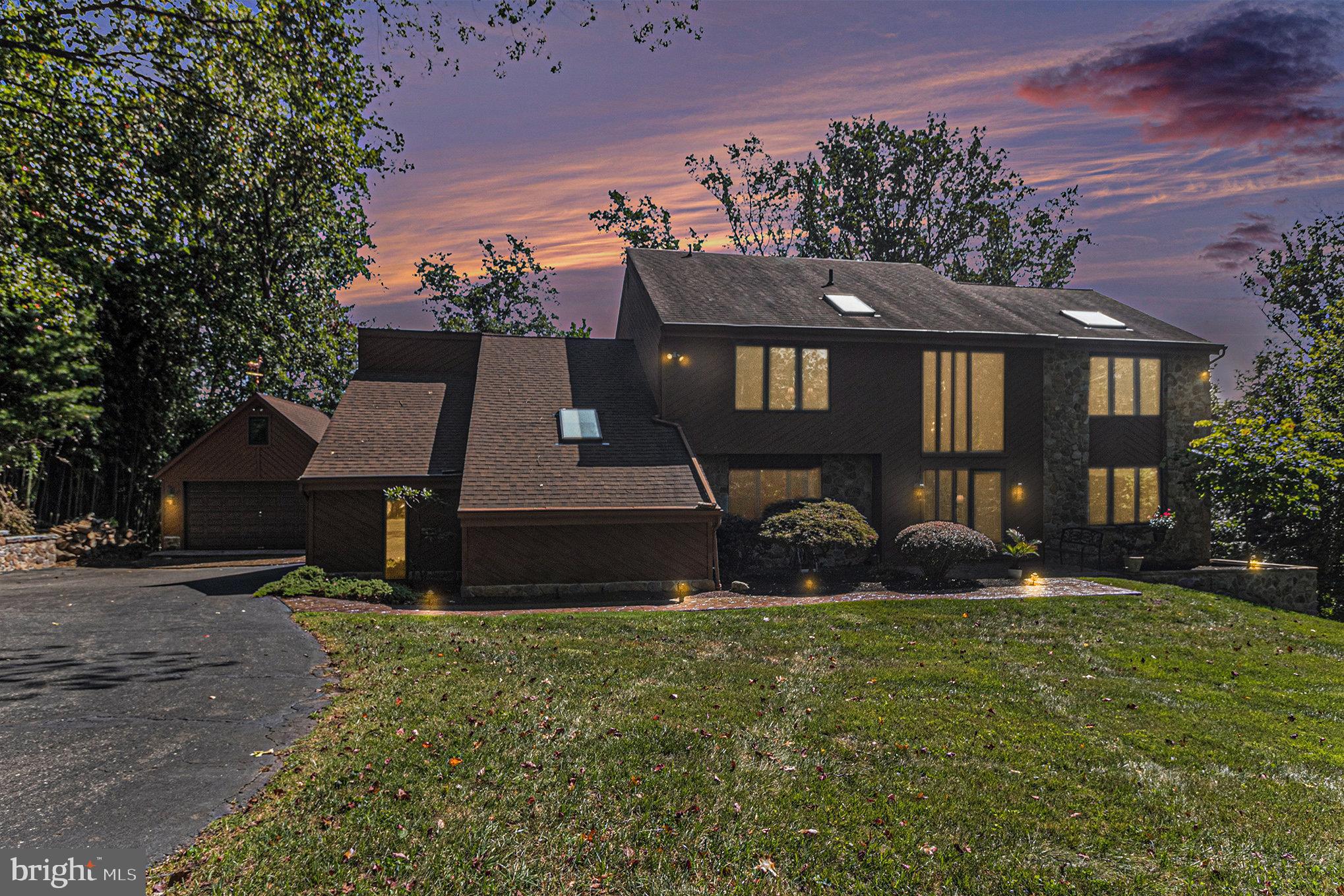 If you’ve been dreaming of a home that feels like a private retreat yet keeps you close to everything, this is it! Tucked away on 1.85 acres at the end of a cul-de-sac in the heart of Glen Mills, this custom-built home, crafted by the builder for his own family, offers an estate-like setting with privacy, elegance, and charm. From the moment you drive up the gorgeous tree-lined driveway, you’ll know you’ve arrived at your very own oasis.
Meander down the stamped concrete walkway and through the front door, and you’re welcomed into a soaring two-story foyer framed by a dramatic glass wall—a grand first impression that sets this home apart from the rest. The main level is designed for both comfort and entertaining. Walk through your bright, spacious living room and you will find tucked in the back, a private office (or 1st flr bedroom) with vaulted ceiling and skylight, while a gracious dining room is perfect for gatherings. You will enjoy cooking in your chef’s kitchen featuring granite countertops, cherrywood custom cabinetry, a built-in butcher block, and stainless steel appliances. Just off the kitchen, the inviting family room features a stunning stone fireplace, the perfect spot to watch the snow fall on a winter evening. From both the kitchen and family room, sliding doors open to a huge composite deck spanning the entire back of the home, offering breathtaking views and the ideal space for outdoor living, whether you’re hosting friends or enjoying a quiet evening under the stars.
Upstairs, the luxurious main suite offers vaulted ceilings with skylight, a walk-in closet, a beautifully remodeled spa-like bath, and French doors leading to your own private balcony—the perfect place for morning coffee surrounded by nature. Four additional spacious bedrooms, all freshly painted and carpeted, complete the second floor.
The finished lower level provides even more living space, filled with natural light, a half bath, and multiple walkouts, making it perfect for a recreation room, gym, or guest space.
Car enthusiasts and hobbyists will love the 2.5-car attached garage plus a detached 2.5-car carriage garage with a huge loft—offering endless options for storage, a workshop, or creative space.
This rare find with incredible views from every window combines the peace of a private retreat with unmatched convenience—just minutes to shopping, dining, and easy access to I-95, Route 1, and 322.