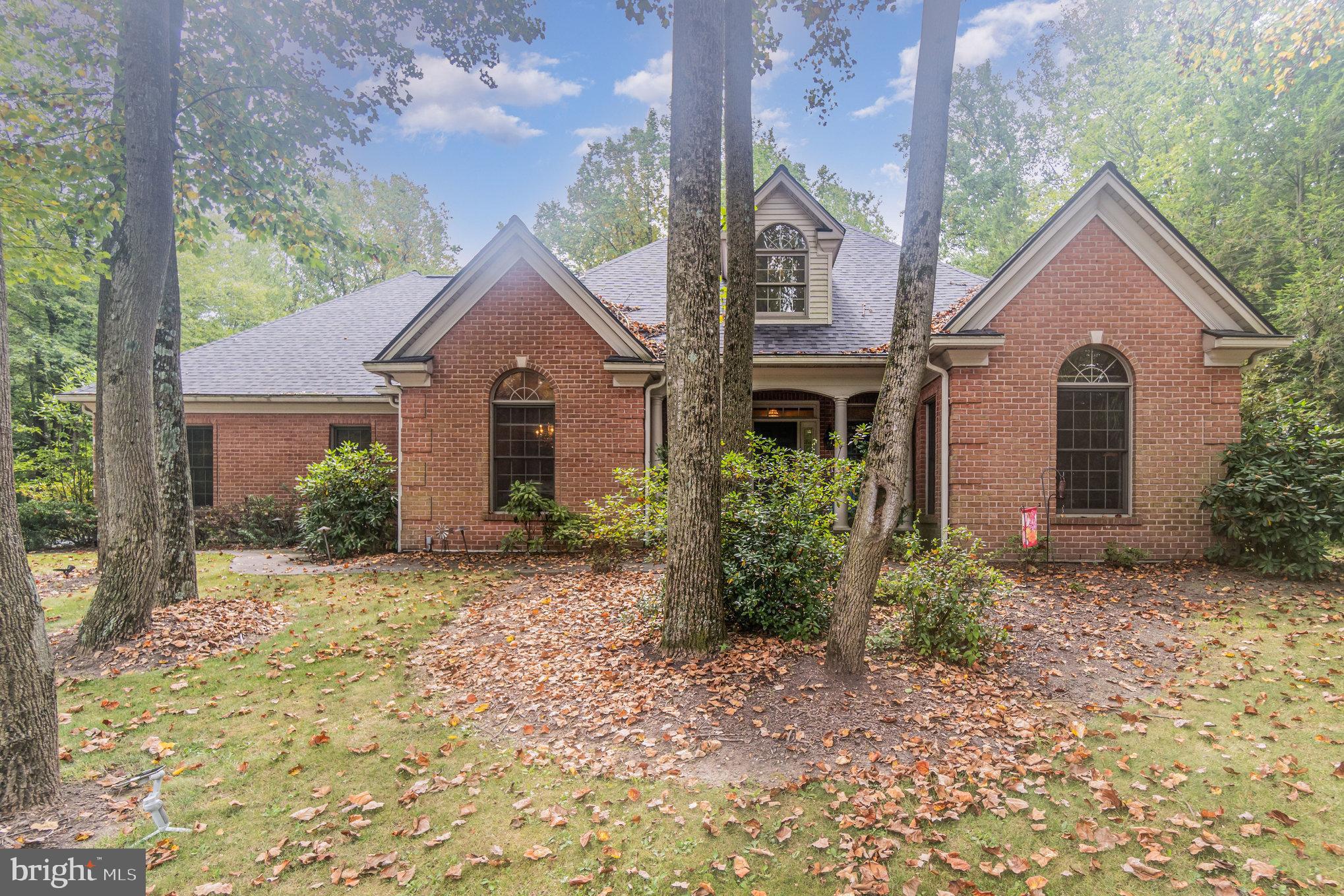 Tucked away on a private, wooded acre in the prestigious Fishing Creek Estates community, this exceptional all-brick home offers over 4,300 square feet of high-quality craftsmanship, thoughtful updates, and serene surroundings—making it truly one of a kind. From the moment you arrive, the home’s timeless curb appeal sets the tone: quoined brick corners, an inviting brick front porch, graceful Palladian windows, and solid 2x6 construction speak to enduring quality. A massive 4-car side-entry garage with insulated 8-ft. Wayne Dalton doors and a hidden RV pad with full hookups offer added practicality for everyday living or adventure-ready storage. Inside, recent upgrades elevate the already stunning layout—new flooring in the main-level family room and powder room, a brand-new roof, and an all-new geothermal HVAC system for exceptional year-round efficiency. The tiled foyer opens to a vaulted family room anchored by a cozy propane stove, while French doors lead to a peaceful screened-in porch overlooking the lush, tree-lined backyard. The heart of the home is the custom Rutt Martin oak kitchen, complete with a large center island—perfect for meal prep, entertaining, or baking marathons. A sunny breakfast nook with floor-to-ceiling windows and an elegant formal dining room let you dine surrounded by nature’s beauty. The spacious first-floor owner’s suite provides privacy and comfort, and upstairs, you’ll find an added bonus: a newly installed second half-bathroom, enhancing functionality for guests and family alike. Throughout the home, solid wood doors, rich oak trim, and detailed molding reflect quality at every turn. A finished lower-level rec room with a full oak wet bar makes entertaining a breeze, while the state-of-the-art Omni Interactive Home Management System allows you to control lighting, sound, climate, and security from anywhere. This is your chance to own a one-of-a-kind property that offers unmatched quality, space, and privacy—all in a convenient and desirable location. Schedule your private tour today and discover the exceptional lifestyle that awaits!