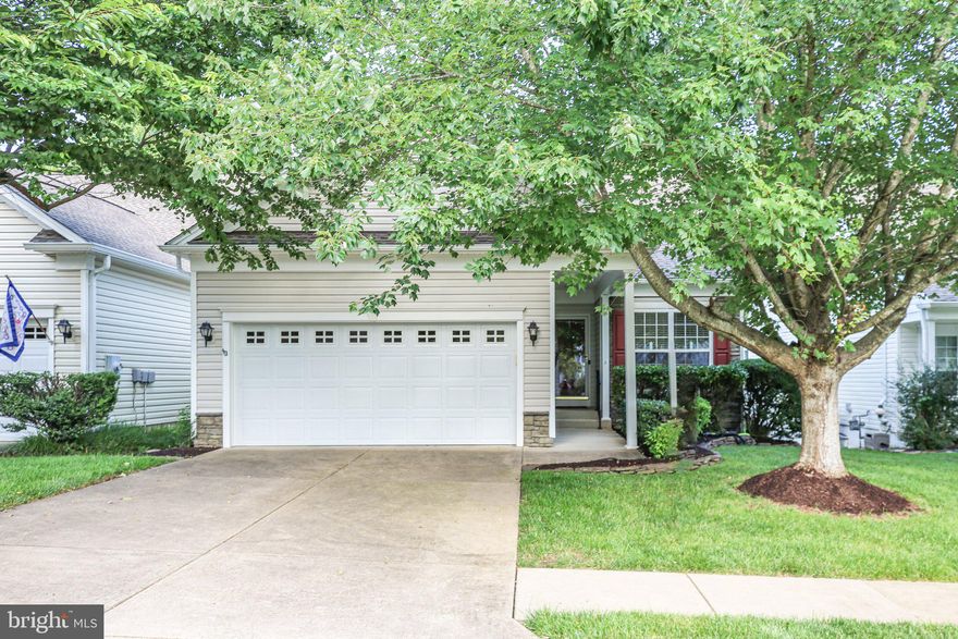 A beautifully maintained James model nestled on a quiet cul-de-sac with no thru traffic in the vibrant Del Webb Active Adult Community of Falls Run. Fresh paint and new carpet bring this home to the market with a fresh and airy approach. Backing to peaceful woods, this home offers the perfect mix of comfort, privacy, and low-maintenance living in one of the area's most desirable 55+ neighborhoods.

From the moment you arrive, the charm is undeniable—beginning with a welcoming front porch and bright center-entry foyer. The well-designed kitchen features light oak cabinetry with one panel of stained glass in the upper corner. Sleek appliances including a built-in microwave, gas stove, and refrigerator with ice maker, generous counter space, make this an inviting place to dine and prepare your meals, and a cheerful breakfast nook with front yard views.

The open-concept dining and family room is ideal for entertaining, with a view of a lovely backyard and tree shaded borders. There is no deck or screened porch, however, a bright and sunny patio is located on the lower level and the sliding glass doors from the family room allow you to plan your own elevated outdoor space to your liking.

The main-level primary suite is privately situated at the rear of the home, offering wooded views, a large walk-in closet, and an ensuite bath with dual vanities and a walk-in shower. A second bedroom at the front of the home doubles as a cozy guest room or home office, conveniently located next to a full bath. The main-level laundry room offers extra storage and leads directly to the attached two-car garage.

Downstairs, the finished walk-out basement adds incredible flexibility with a 3rd bedroom and 3rd full bath—perfect for visitors—as well as an expansive Rec Room that opens to a concrete patio for outdoor dining or relaxing. A large utility/storage room provides all the space you need without compromising your lifestyle. There's so much storage in this house that there is no need to downsize! Bring all your treasures and find a place for them as you unpack. 

Located just minutes from the community clubhouse, you are just steps from resort-style amenities including tennis and pickleball courts, indoor and outdoor pools, billiards, fitness classes, guest parking, and a full calendar of events curated by a full-time Lifestyle Director.

Whether you're hosting friends, enjoying quiet evenings in the woods, or joining in on daily activities, this is the lifestyle you’ve been waiting for. Come see why life is better at Falls Run—schedule your private tour of 14 Sugargrove Court today!