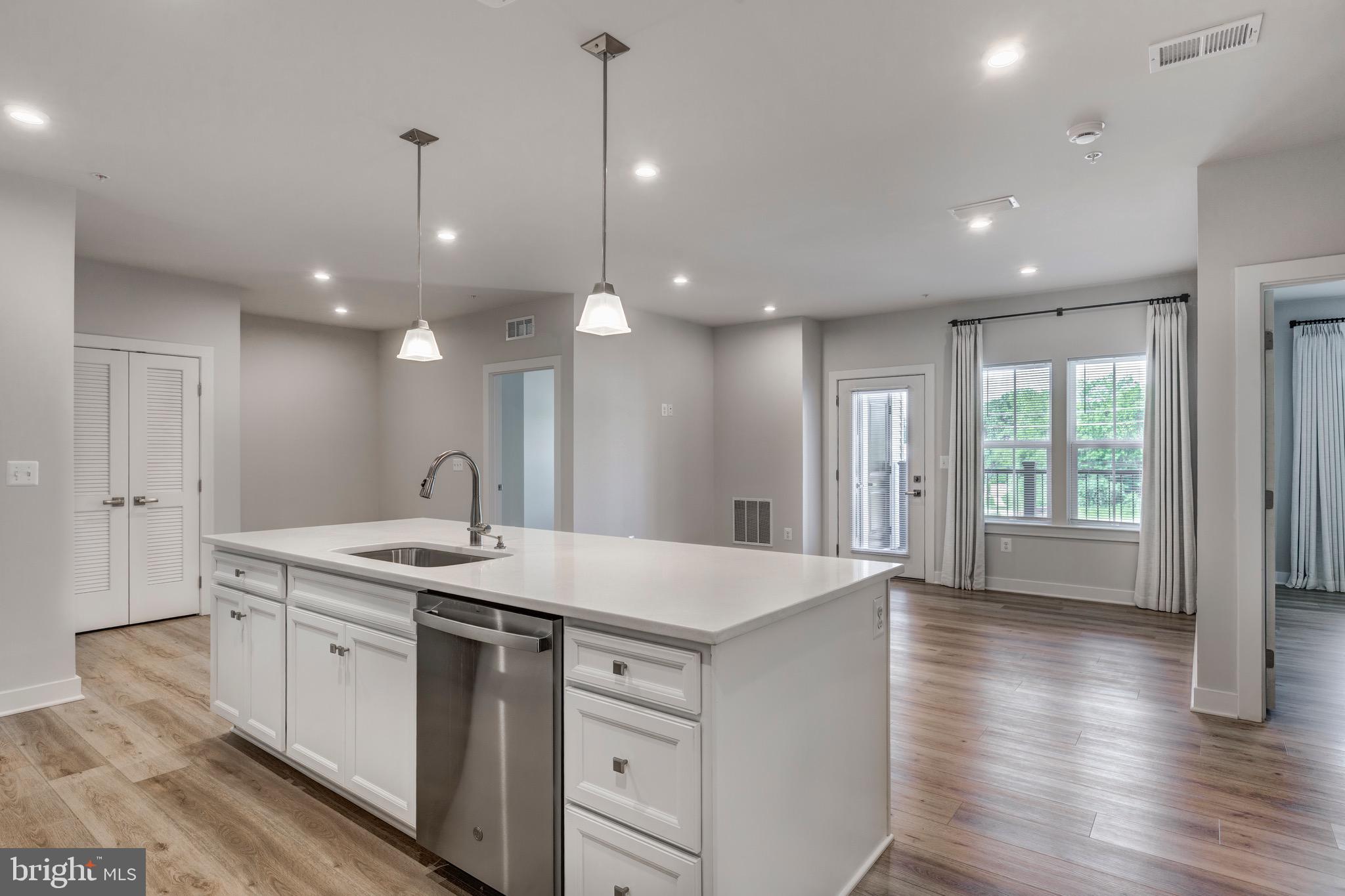 Located in Sykesville, MD, this stunning 2-bedroom, 2-bathroom condo at 42 Liberty Rd #M is nestled within a luxurious 55 and over community, offering the perfect blend of comfort and sophistication. Built less than a year ago, this modern residence boasts a sleek and contemporary design. The interior features luxury vinyl plank flooring throughout, complemented by a spacious open layout that seamlessly integrates the kitchen, dining, and living areas. The kitchen is a culinary dream, equipped with quartz countertops, a large island with seating, white cabinets, a pantry, and stainless steel appliances. Both bathrooms are adorned with quartz countertops, with the primary bathroom offering dual sinks, a large walk-in closet, and a walk-in shower. The condo’s neutral paint scheme and recessed lighting create a bright and inviting atmosphere, while high ceilings add to the sense of spaciousness. Additional conveniences include a stacked washer and dryer, and a balcony perfect for relaxing. This condo is part of a vibrant community designed to enhance the quality of life for its residents, providing a low-maintenance lifestyle ideal for those seeking to enjoy their golden years in style. Transferrable builder warranty included.