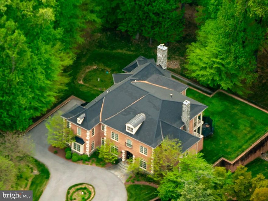 Introducing 7020 Mountain Gate Drive—a distinguished brick residence tucked at the end of a quiet cul-de-sac in the sought-after Bethesda section of Avenel, one of the area’s most prestigious communities. Perfectly situated on a one-acre lot, with sweeping wooded views, this custom-built 2014 home offers an impressive floor plan spanning more than 10,000 square feet. The gourmet kitchen is a true chef’s delight, showcasing an open layout with dual islands, abundant custom wood cabinetry, and rich granite countertops. The kitchen opens seamlessly into the great room, where soaring 21-foot ceilings create a dramatic backdrop. A striking stone-surround gas fireplace serves as the focal point, while walls of windows flood the space with natural light and capture the surrounding scenery. This three-story stone fireplace serves as a striking architectural centerpiece and a magnificent accent to the home. Beyond the great room, a serene office enclosed by windows and enhanced with a tray ceiling offers a bright and quiet retreat for focused work. At the front of the home, just off the main foyer, a secondary office enclosed by French doors provides an equally sophisticated setting—perfect for today’s remote lifestyle. The generously sized dining room, framed with chair-rail molding and illuminated by an elegant chandelier and sconces, provides the perfect setting for hosting large gatherings. An inviting formal living room, centered by a gas fireplace, creates a quiet yet refined lounge, while just beyond, an outdoor terrace offers a fabulous space for open-air relaxation. Everyday convenience is found in the well-appointed mudroom, complete with built-in cabinetry, a washer and dryer, and access to the three-car garage. The upper level boasts a unique floorplan with five spacious sized bedrooms, each featuring its own en-suite bathroom. The primary suite is a true retreat, highlighted by ten-foot ceilings and an expansive layout. It offers an oversized bedroom, a private sitting area with backyard views, a quiet terrace, and a cozy gas fireplace. A grand double-door custom walk-in closet with custom built-in cabinetry throughout, and a luxurious spa-inspired bathroom, complete with a grand walk-in shower, soaking tub and dual vanities, make this space the ultimate sanctuary. Continue down the hallway to discover four additional bedrooms, each with its own walk-in closet. A secondary staircase at the rear of the home provides convenient access to the kitchen and great room below, while also offering a dramatic overhead view of the great room. The lower level of this home is designed for every activity, offering nearly 3,300 square feet of beautifully finished space. The private home theater delivers an authentic cinematic experience, featuring stadium-style reclining seats, full projection, and immersive surround sound—all bringing the magic of the movies to the comfort of your home. Two sizable bedrooms are connected by a Jack-and-Jill bathroom featuring both a tub and shower, while a secondary powder room is available for guests. The lower level opens to a private patio overlooking the flat, expansive lot. 7020 Mountain Gate Drive is an extraordinary offering in the sought-after Avenel community, showcasing a truly distinctive floor plan in one of its most desirable sections. Ideally located with effortless access to Clara Barton Parkway, I-495, and just minutes from Potomac Village and Great Falls National Park, this home combines convenience with unparalleled amenities. Residents of Avenel enjoy exclusive access to community pools, parks, and tennis/pickleball courts—all included in the monthly association fee. Even better, exterior landscaping is maintained by the HOA, allowing for worry-free living. With its rare blend of features, amenities, and location, opportunities like this are few and far between—do not miss this premier residence.