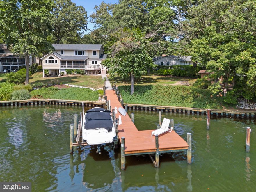 Feel right at home in this stunning 3-bedroom, 2.5-bath, 3,970 sqft waterfront property perfectly located in the heart of the sought-after Berrywood community with 160+ ft of waterfrontage on serene Cattail Creek. This Severna Park home provides the coveted waterfront trifecta of public water, public sewer and natural gas plus a great school district and captivating water views of Cattail Creek. Renovated in 2016 by the renowned local architecture firm Purple Cherry Architects, this home exudes quality and thoughtful design. The interior boasts a seamless flow, with an open kitchen equipped with high-end appliances and an island, a breakfast nook with a vaulted ceiling, and an outstanding screened porch overlooking Cattail Creek. The living room and adjacent seating area also enjoy wonderful water views across the expansive backyard and creek. The formal dining room, mudroom, powder room and office with water view complete this level. Upstairs, the primary suite boasts enormous windows that frame the wonderful water views and let the natural light pour in.  The suite also features a cozy sitting area, custom closet and a spa-like bath with a soaking tub, walk-in shower, and double sinks. Two additional spacious bedrooms share a hall bath, and the large laundry room is conveniently located on the bedroom level. The finished lower level offers a versatile great room, reading nook, an office or gym area, 2 large storage rooms and a walk out patio. The direct access to the backyard and waterfront provides easy access to enjoy all the perks of living on the water. A private pier with a boat lift, storage shed, fishing platform and waterfront seating areas enhance the appeal of this waterfront property. This exceptional property combines luxury, comfort, and a prime location, offering the best of waterfront living in the picturesque Berrywood community. This wonderful community offers an array of amenities, including sports fields, a swimming pool, pickleball/tennis courts, a boat ramp, kayak launch and a marina. Make this exquisite property your new home and enjoy the serene views and vibrant community life it offers. Welcome Home!