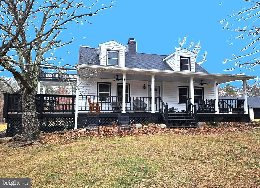 Nestled between the mountains, this charming farmhouse-style residence offers a harmonious blend of modern comfort and rustic charm. With 4 spacious bedrooms and 2 full bathrooms, this home is designed to cater to your every need, providing a warm and inviting atmosphere that always brings you home.  Step inside to discover an open floor plan that seamlessly connects the family room and kitchen, making it ideal for gatherings and everyday living. The kitchen boasts upgraded countertops, a central island, and stainless steel appliances, including a dishwasher, garbage disposal and electric oven/range ensuring that meal preparation is both enjoyable and efficient. The cozy breakfast area invites you to savor your morning coffee while basking in the natural light that floods the space through new energy-efficient windows. The living area features beautiful hardwood floors and exposed beams, adding character and warmth to the home. A brick wood-burning fireplace serves as a focal point, perfect for cozy evenings spent with loved ones. Major renovations completed in 2022 and 2025 have elevated this home to excellent condition ensuring that you can move in with peace of mind. The partially finished basement offers additional space for recreation or storage, complete with two sump pumps and a water treatment system for added protection. Outside, spanning an impressive 26.5 acres, this property offers a private and secluded retreat surrounded by nature and the tranquility of mountain living. The wrap-around porch and upstairs bedroom balcony beckon you to relax and soak in the natural beauty all around you. Thoughtful exterior features include landscaping with fruit trees, a grape arbor, a garden, a swing, a hammock and several picnic tables for enjoying the beautiful outdoor space.  Additional features include a new more efficient gutter system as well as new siding, and multiple outbuildings, including a shed, a wood storage shed and a poultry house, providing ample storage and versatility. Parking multiple vehicles is a breeze with a circular driveway leading to an oversized 1500 square foot 4 bay detached garage with loading dock that easily accommodates more than four vehicles and a generous workspace. The lot is unrestricted, allowing for farming, horseback or ATV riding, gardening or hunting and shooting as several berms are already in place.  Whether you're seeking a peaceful retreat, a hobby farm,  or a place to entertain, this property is a true gem that promises comfort, convenience, and a connection to the great outdoors. Here you will enjoy year round access to your own private oasis. Don't miss the opportunity to make this enchanting residence your own where every day feels like a getaway!