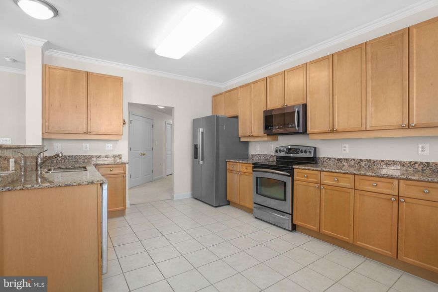 2 bed, 2 bath corner unit just shy of 2,000 square feet with partial marina water views from a spacious private balcony. Additional features include three parking spaces consisting of two garage spaces and one reserved exterior space. Building allows for garage EV chargers. Storage unit included.  Open kitchen concept with granite countertops, stainless steel appliances, and a breakfast bar with seating that opens to the dining and living area with fireplace. Freshly painted walls and professionally cleaned carpets. Washer and dryer in unit with spacious laundry room. Water and trash are included in condo fees. Building has ramp access in exterior of building next to 3rd parking space. This vibrant waterfront community offers exceptional amenities including an outdoor pool, tennis courts, and miles of scenic walking trails that lead directly into the Occoquan Wildlife Refuge. Residents enjoy convenient access to shops, dining, and entertainment, blending natural beauty with urban accessibility. For commuters and travelers, the VRE and Amtrak station located within the neighborhood provides easy access to Washington, D.C. and beyond. I-95 Express Lane entrances are just minutes away. Offering a rare combination of space, comfort, and location, this private corner condo is a one-of-a-kind opportunity for the discerning buyer.