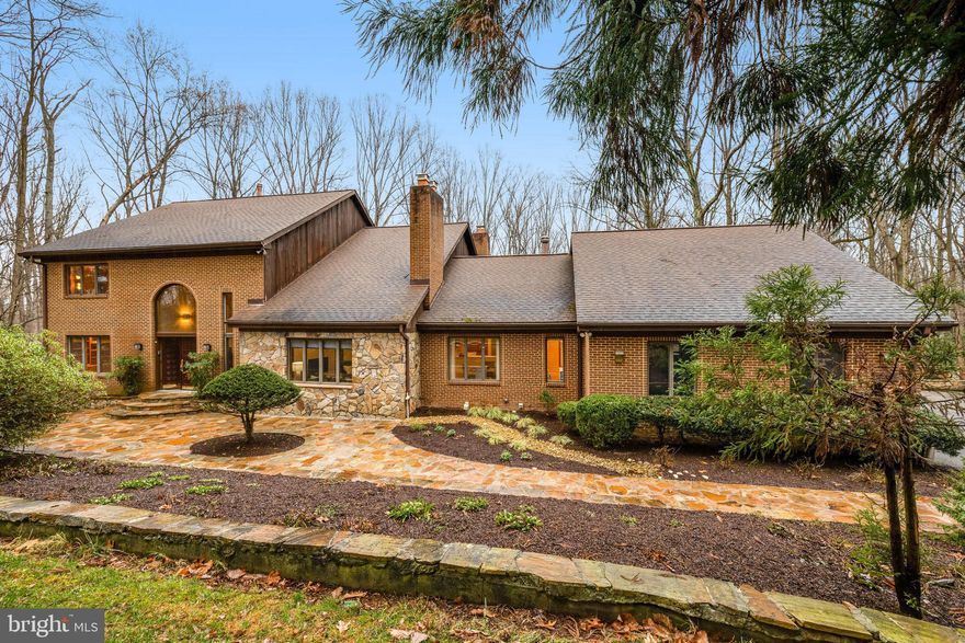 Beautiful 5.25 acre property in private enclave of Vienna offering 5 bedrooms, 4 full baths and 2 half baths with 7300 sq. ft.  of living space  This lovely home has been meticulously maintained and recently updated the bathrooms. The renovated kitchen, adorned with white soft-close cabinetry and Calacatta quartz countertops, is a chef's delight, equipped with top-of-the-line stainless steel appliances including Wolf Microwave, Miele induction cooktop, wall oven, Dishwasher, and Sub Zero Refrigerator. The adjacent breakfast room overlooks the picturesque front garden.  A main level owner's suite featuring a spacious bedroom and an octagonal sitting room with picturesque views of the sprawling acreage. The  updated spa-inspired bath is a sanctuary of relaxation with its steam shower, jetted tub, and vaulted ceiling, leading out to a charming brick walled terrace nestled amidst the lush greenery. Step inside to the awe-inspiring great room, where a floor-to-ceiling stone-clad wood-burning fireplace takes center stage, flanked by soaring windows that flood the space with natural light. Entertain with ease in the expansive dining room, seamlessly connected to a screened balcony offering serene views of the wooded surroundings. A spiral staircase descends to the deck below, perfect for outdoor gatherings. The Upper level provides 3 bedrooms and 2 full baths, offering ample space for family and guests. The lower level is a haven for entertainment, boasting a family room with brick wood-burning fireplace, a game area,  ensuite bedroom with built-in desk and a versatile rec room. Step outside to the expansive deck, spanning almost the entire width of the home, and enjoy the serene outdoor ambiance. Outdoors, mature trees, terraces, and gardens create a peaceful retreat, while ample play space in the front and back yards beckon outdoor enjoyment. Shed the cares of the world and immerse yourself in the tranquility of this idyllic oasis.
