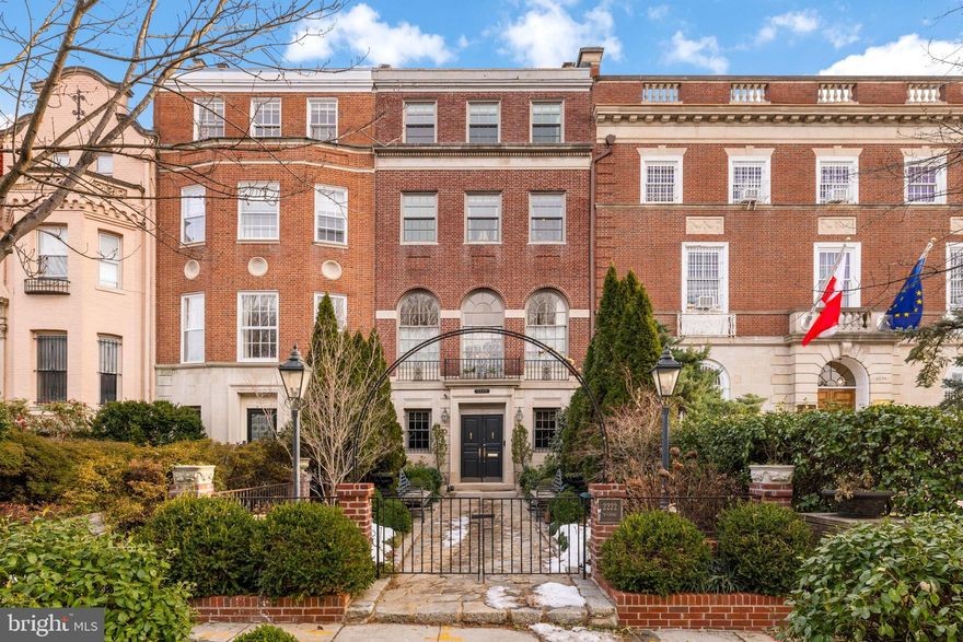 Built in 1923 for Washington grocer and businessman John Holmes Magruder, this grand Georgian Revival residence offers over 5,890 square feet of finished living space on four elegant levels. 
Elevated above the street with a Piano Nobile, the home’s distinctive architecture allows for a dramatic entry hall and a very wide formal living room with 10' ceilings and a fireplace. The main entertaining floor also includes a formal dining room, large open kitchen with island, and a windowed breakfast room with sky views, powder room and elevator access. A private motor court and garage also have elevator access and connect directly to the lower level with a mudroom, laundry, office, storage, and full bath. Upstairs, the primary suite with elevator access spans the rear of the third floor with two walk-in closets, and a spacious bath. Additional floors offer 3 more bedrooms, a paneled library, and a top-level balcony with sweeping views.
Thoughtfully renovated in the early 2000s, the home retains its classic character—arched openings, Palladian windows, rich millwork—while offering the convenience of modern systems, appliances, and fixtures. Located in the heart of Kalorama, surrounded by embassies and Rock Creek Park, this is a rare opportunity to own a piece of Washington’s architectural legacy.