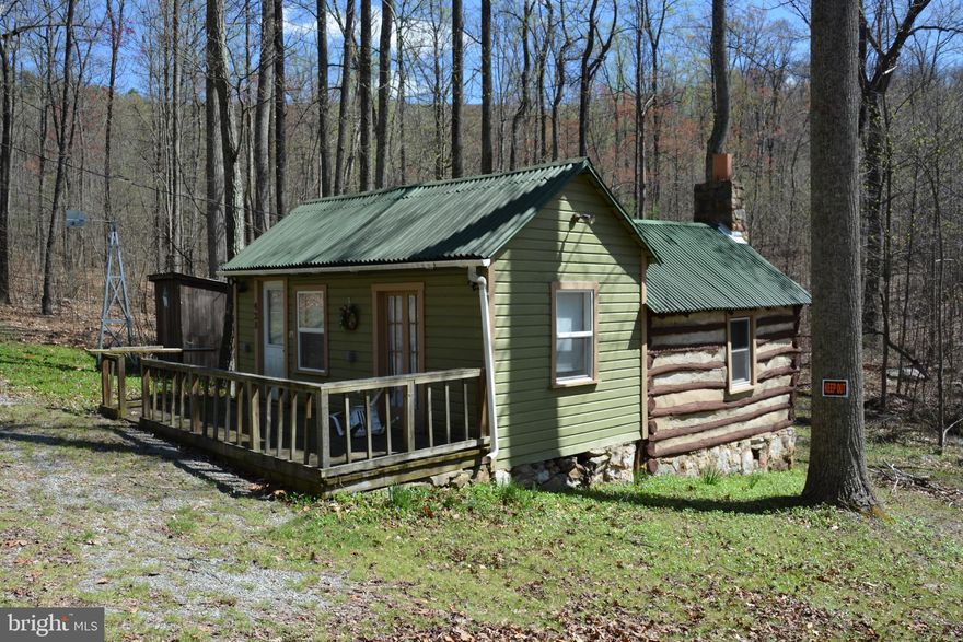 File this one under unique properties. This tiny cabin is located on 21+ acres.  The land was originally subdivided into 4 lots;  (3) are 5 acres,  the lot with the cabin is 6.23 acres.   All are contiguous and being offered together.  The Subdivision is called North Mountain Estates.  There is NO HOA here, NO fees are collected and there are NO restrictions. The cabin has electricity, but no well or septic.  There is an outhouse. The tax record is incorrect in date built.  The owner offers that the log was harvested from the land and the log part was built in 1950. There is a wet weather stream just behind the cabin that may run through all 4 lots.  The water was cascading nicely after rain this week. The 4 lots have long frontage on Sawlog Rd (over 1/2 mile). Ask for the plat before venturing out on your own to walk the land, or contact an agent.  Sawlog is a little rough so 4WD or AWD is suggested. THE COVE and CAMP ROCK ENON are within minutes of the property. Check online to see the wonderful facilities they offer.  The Tuscarora Trail is also in fairly close proximity.