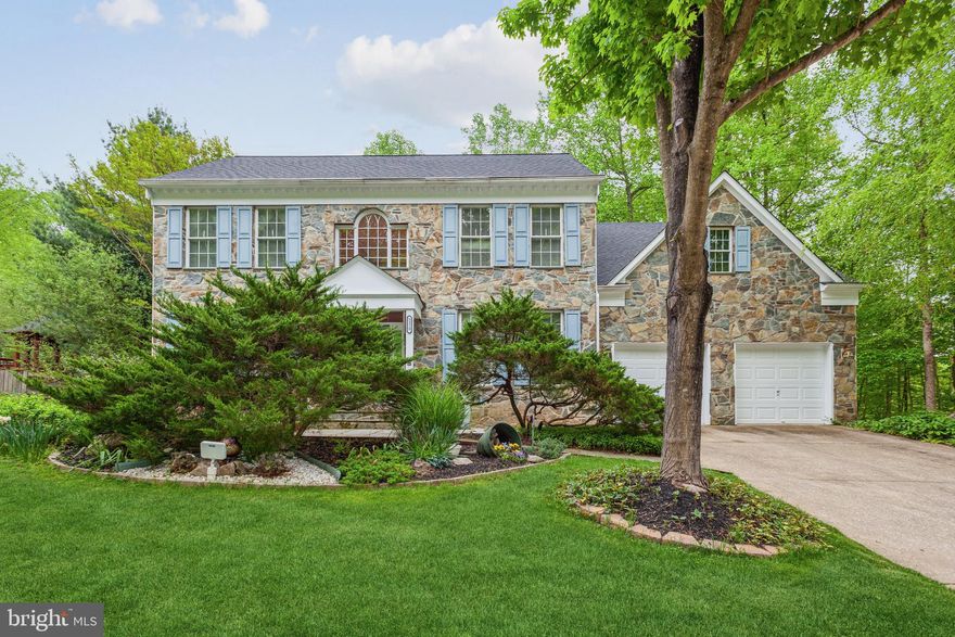 What a beauty!  Stone front Williamsburg Builders model home containing 3 finished levels. The main level has hardwood floors throughout, a quiet library with custom built-in oak book-shelves and double French doors set to the side with 2 story family room, luminous windows bring a lot of natural light to the house, 2 story stone gas fireplace will make you cozy and warm during cold winter evenings. Sunlit breakfast area with French doors to a custom expansive freshly painted deck with inviting gazebo backing to wooded area. Bay windows in the dining room + formal living room. A large updated kitchen (2020) with granite countertops, island with stove top in the middle, double sink. 2 stair cases. Upstairs  you will find a huge primary bedroom with vaulted ceiling and walk-in closet. Luxury bathroom is complete with large soaking tub, separate shower with new shower head (1 month), and 2 sink areas. Three more bedrooms complete the upper level with hardwood floors everywhere. The shared bathroom upstairs has dual sinks. Lower level has a completely finished basement with carpet + laminate flooring . Spacious family room, recreation room and additional room used as an exercise/bonus or extra bedroom, double doors to the back yard. Tons of storage! This home flexes to fit your needs and lifestyle. It is located in “The Trails at Woodlots” neighborhood with access to some of Howard County amazing hiking trails, 3 miles away from Centennial Park with a beautiful lake, walking distance to the nearby Columbia Athletic Club, Harpers Choice Village Center with Safeway grocery store and variable dining options, Hobbits Glen Golf course is nearby, 2,5 miles to Columbia Mall, Columbia Town Center and Merriweather Post Pavillion. Architectural Shingle Roof (April, 2021), HVAC (2015), Water Heater (2017), freshly painted bathrooms’ walls and ceilings. Does not have Columbia Association and Recreation fee.   Do not miss this gorgeous home!