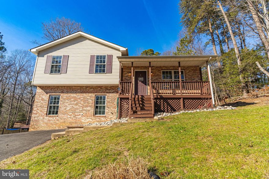 Cute as can be and ready for you! Check out this adorable split level, complete with the old-fashioned front porch overlooking the quiet drive, a large back deck, AND backing to trees! This home has been refreshed with fresh neutrals colors. An open kitchen and family room flow into the deck area out back. Upstairs, you'll find more low maintenance vinyl plank flooring, a gorgeous primary. The basement is perfectly arranged to spread out, separate laundry space, and a flexible rec-room, all with tons of natural light through full sized windows and sliding doors to the backyard. CRE offers tons of special amenities, including sandy beaches on the Chesapeake, Clubhouse facilities, community gardens, playgrounds and more! Located a short commute from PAXNAS, shopping, rec centers, public swimming pools, and more!