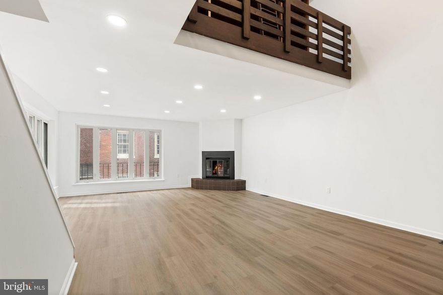 101 Naudain Street is a distinctive end-row multi-level home in the heart of historic Queen Village, offering a rare combination of architectural character, flexible living space, and private outdoor areas. Enjoy natural light from both the front and side of the home. Enter through the garage or gated entry into a welcoming hall with a convenient coat closet. The lower level features a large tiled room with a half bath and laundry hookups, perfect for a home office, guest suite, or creative studio. Upstairs, the living room radiates sunlight with floor-to-ceiling windows, custom built-ins, and a fireplace, complemented by a dramatic atrium that looks up to the library/gallery above. The kitchen opens to a walled European-style garden, while a separate hall door leads to the beautifully maintained, gated courtyard shared by the HOA. The middle floor offers two bedrooms, a full bath, a linen closet, and the library, with the larger bedroom featuring oversized windows and a balcony. The top floor spans the entire depth of the home as a full primary suite with picture windows, an en-suite bath with a jetted tub, abundant closets, and potential for a rooftop deck. With ample storage, versatile spaces, and historic charm, this home provides a unique opportunity in one of Philadelphia’s most iconic neighborhoods—near cobblestone streets, Headhouse Square, waterfront access, and world-class dining, shopping, and cultural attractions.