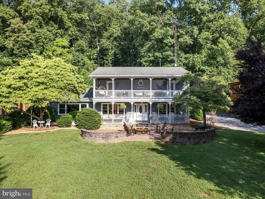 An extraordinary waterfront retreat nestled right on the Potomac River in Harpers Ferry, this stunning and spacious home offers rare deep-water access and a private floating dock, perfect for boating, jet skis, fishing, and year-round water recreation. Relax and entertain on the beautifully crafted two-level front porches, or gather around the outdoor brick patio with a firepit—all with serene river views. Inside, you’ll find impeccable craftsmanship and thoughtful updates throughout. The bright entry foyer leads to a cozy sitting room and formal dining area with gleaming hardwood floors. The expansive eat-in kitchen boasts stainless steel appliances—including a new refrigerator and dishwasher—double ovens, walk-in pantry, and a generous island that opens to a vaulted family room with exposed beams, LVP flooring, and a striking stone fireplace with an enameled wood stove. A laundry room, office, and full bath sit off the kitchen, along with a large bonus room—now converted into a bunk room/4th bedroom—featuring a dedicated mini-split system for comfort. Upstairs, three spacious bedrooms await, two of which open directly onto a newly screened-in upper veranda, offering peaceful views and fresh breezes. The luxurious primary suite includes a clawfoot tub and high tank toilet with gold-plated hardware. With two long garage bays, an EV charger, and close proximity to the Appalachian Trail, C&O Canal, and commuter routes, this home is a rare blend of natural beauty, comfort, and accessibility—perfect for year-round living, a weekend escape, or short-term rental income.