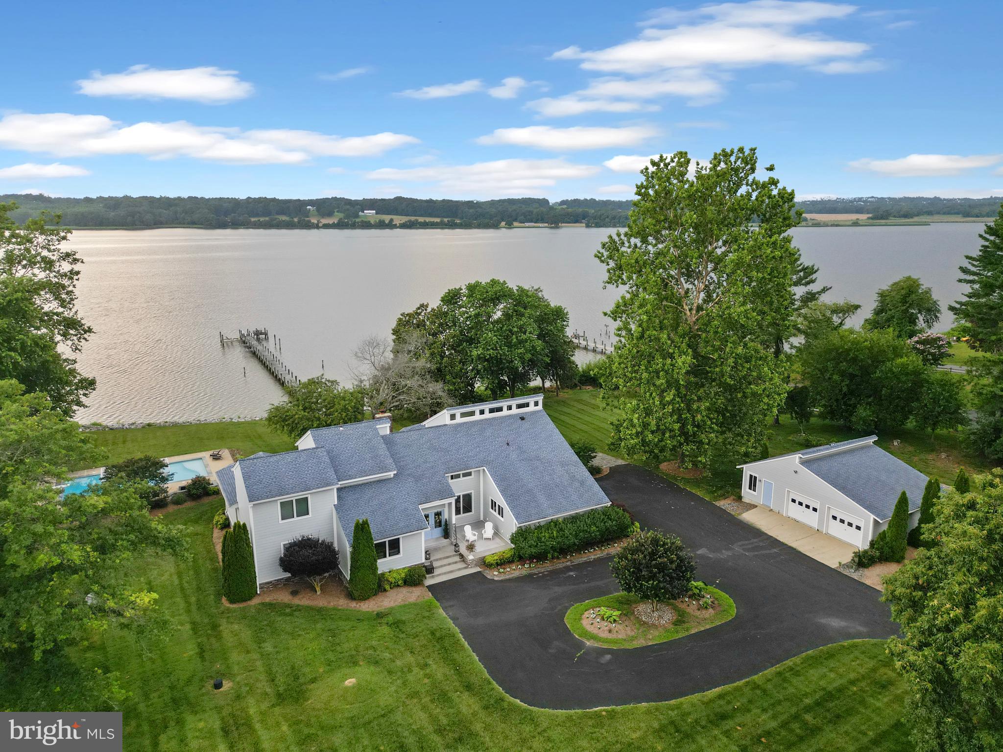 Nestled along the scenic Patuxent River, this exceptional waterfront home offers the perfect blend of elegance, comfort, and coastal charm. Spanning over 3,900 square feet, the residence features four spacious bedrooms and three and a half baths, including a luxurious first-floor primary suite designed for both privacy and convenience. Set on 3.75 picturesque acres, the property invites you to savor tranquil river views and outdoor living at its finest. A beautiful pool overlooks the water, creating an idyllic backdrop for relaxation or entertaining. Inside, a custom kitchen serves as the heart of the home, while multiple living areas provide space for gatherings large and small. In addition to the attached two-car garage, a detached two-car garage offers a versatile shop or party space, perfect for hobbies or hosting. This is more than a home—it’s a private retreat where every detail is designed to make the most of its breathtaking waterfront setting.