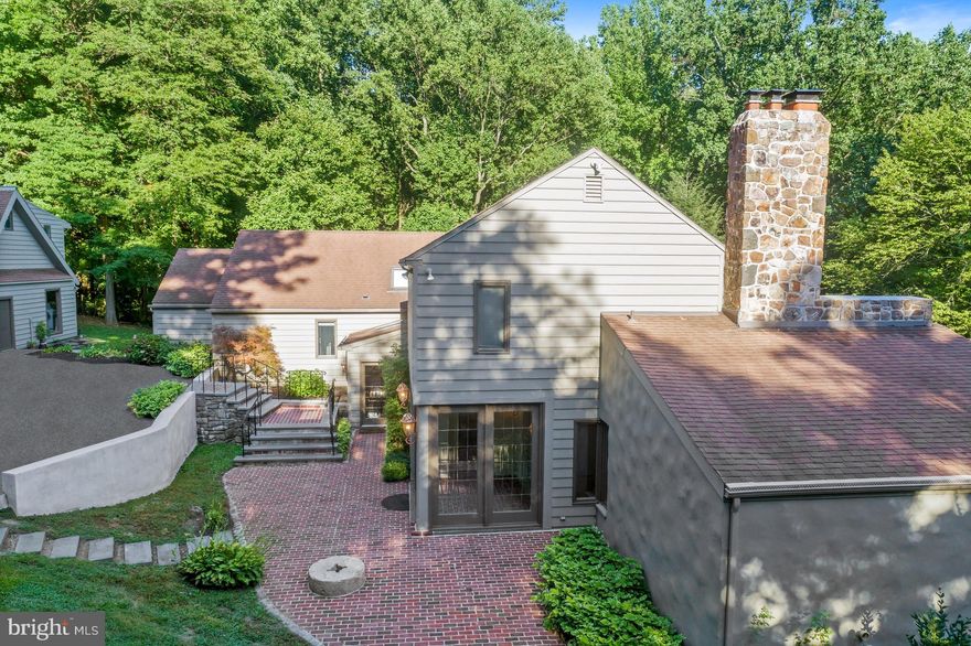 You'll love coming home to this property! Welcome to this contemporary-style build in Chadds Ford within the award-winning Unionville-Chadds Ford school district. Set on 5 acres with partially wooded views, this property offers a natural and private setting. Enter the driveway through an ornate metal gate and wind up a long driveway. From an expansive brick patio, enter into the foyer by way of a mudroom. Continue through into an open and flexible living space. An updated kitchen features high-end appliances, island with seating & custom cabinetry and opens to a breakfast area and an open family room with a double-sided full stone fireplace including pass through to living room on the other side. The kitchen & family room have a 2-story, vaulted ceiling. A formal dining room sits off of the eat-in kitchen. Two entrances lead to a wrap-around deck with outdoor fireplace (with deactivated propane line) overlooking the elevated views of the Brandywine Valley. Pass a powder room as you head up a half flight of steps to find 3 large bedrooms, 1 with the option for a private bath and 2 sharing a hall bath. A nearby laundry room creates convenience for guests/family. Move up another half flight of steps with unique iron railing to the large primary suite featuring large bedroom, walk-in closet with shelving system, bath with soaking tub, walk-in shower & his/hers vanities and private office with fireplace. From the main level head down a half flight of steps to find a private suite with full bath and plenty of closet space. Continue down again to a massive walk-out game room with high ceilings, fireplace with wood stove and unfinished utility room for storage. With over 5,000 sqft of living space this home lives large and provides tons of space for formal and informal entertaining, spaces to enjoy the outdoors and in-home offices/gyms. A detached 3-car garage has a finished studio apartment above with full bath and kitchenette. Relax by the pool with brick surround and manicured landscaping. Enjoy gardening or have chickens roam in the chicken coop. This home is perfectly located with easy access to Rt 202, downtown Wilmington, Greenville, Kennett Square and all that the area has to offer.
