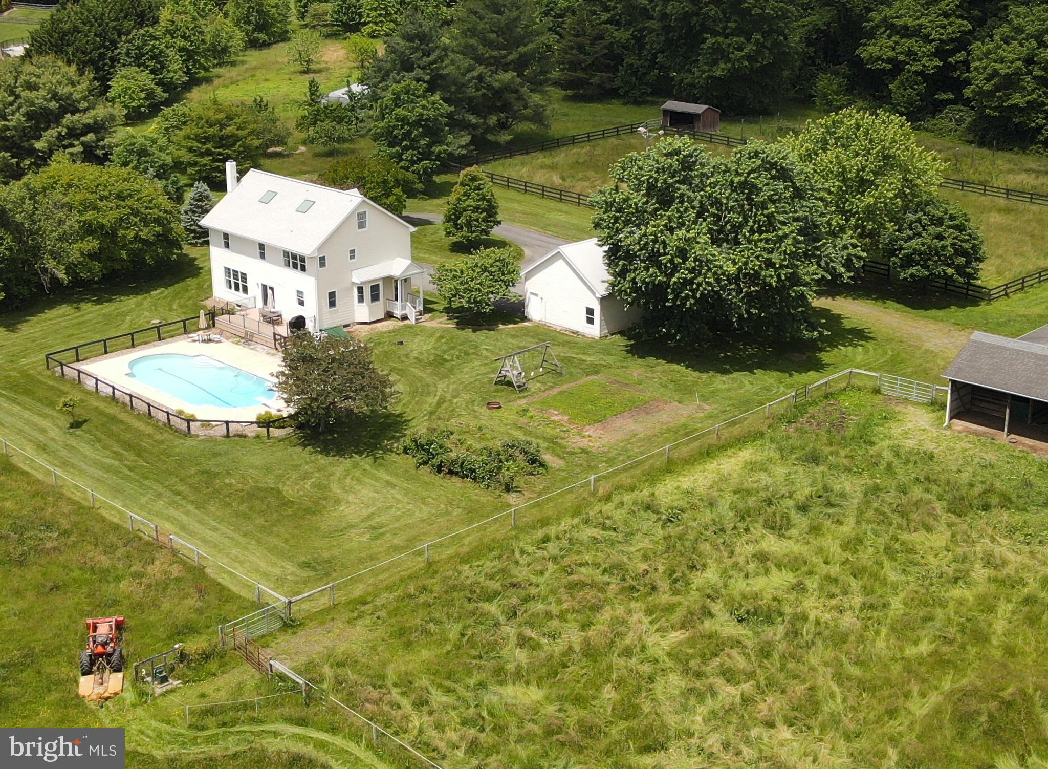 Equestrian Estate with Elk River Views and Access
14 Acres - Chesapeake Bay Lifestyle Meets Horse Country
This custom colonial home sits prominently on 14 acres overlooking the Elk River and the mouth of the C&D Canal. The property offers a unique combination of equestrian facilities with the water-oriented living that defines the Chesapeake Bay lifestyle. Horse enthusiasts will appreciate the south-facing four-stall shed row barn that includes a tack room and generous equipment storage areas. The property features two lighted riding rings, one with a grass surface and the other with sand and rubber footing for year-round training. Rolling organic pastures provide excellent grazing for horses, while 20 acres of preserved open space border the property and offer trail riding and hunting opportunities. The property is just 25 minutes from Fair Hill's premier equestrian events and training facilities. The energy-efficient 4-bedroom colonial incorporates thoughtful features including R-20 insulated walls, passive solar orientation, and an environmentally friendly geothermal heating and cooling system. The open, expansive main level features natural pine flooring throughout, with 9-foot ceilings that enhance the sense of space. The large living area centers around a stone-faced wood-burning masonry heater and provides plenty of room for gathering with family and friends. This main level flows seamlessly between the kitchen, formal dining room, living room, private study, powder room, and convenient laundry facilities. The second floor houses the primary suite with a year-round view of the ships sailing to and from the Baltimore Harbor, with a walk-in closet and private bathroom, along with three additional bedrooms that share a full bathroom. The third floor provides valuable flexible space with skylights, a half bath, and a separate room that easily adapts as a home office, guest suite, or media room. The lower level showcases an authentic Finnish sauna complete with shower and changing room, creating the perfect opportunity to warm up before taking a refreshing plunge in the pool. The remaining basement space offers extensive recreation and storage areas to accommodate country living needs. Outdoor amenities center around the recently renovated 45-foot swimming pool with its center lane stripe and a new deck with beautiful pasture views. The three-car detached garage includes ample storage space, while mature landscaping creates park-like grounds featuring a productive orchard and garden. The property has community access to the Elk River for boating, fishing, and various water recreation activities. This rare combination of substantial private acreage, equestrian facilities, and water access delivers the authentic Chesapeake Bay lifestyle while maintaining the privacy that preserved open space boundaries ensure will continue for years to come.