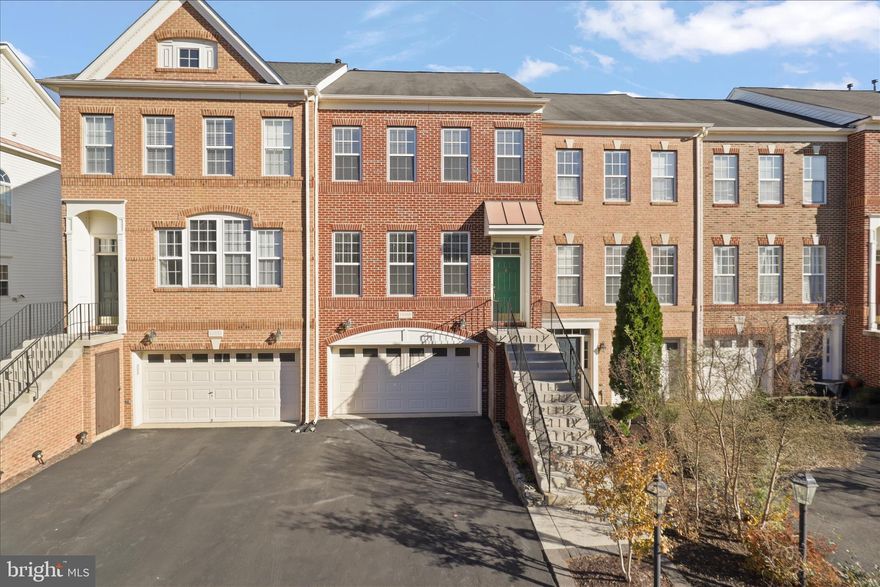 Welcome to beautiful brick front townhome with 2 car garage, nestled in the heart of Stone Ridge subdivision  - This beautifully maintained townhome features 4 bedrooms, 3 full bathrooms and 1 half bathroom with over 2170+ square feet of finished space on three levels - This home has ceramic tiled foyer entry, hardwood floors on the entire main level, upper level and stairs and has two gas fireplaces - Living and dining room combo area with oversized windows which flows seamlessly to your updated gourmet kitchen with stunning oversized waterfall quartz island, stainless steel appliances and upgraded cabinets with soft close drawers - Adjacent to the kitchen is the family room with a gas fireplace - Sliding glass door opens to your spacious deck overlooking your yard - Master bedroom has vaulted ceiling, recessed lights, ceiling fan and his and hers closet space with shelving - Updated master bathroom has ceramic tiled flooring, separate tub and shower and dual vanities. The fully finished walkout lower level recreation room has one bedroom and one full bathroom, gas fireplace, recessed lighting - Step out to enjoy your stone patio (2022) with fully fenced backyard - perfect for outdoor entertaining- Ideally located near gum spring library, medical offices, shopping center, and restaurants - Enjoy Stone Ridge outstanding amenities including pools, clubhouse, gym and neighboring playgrounds - Close proximity to Rt 50, Rt 28, Dulles Airport