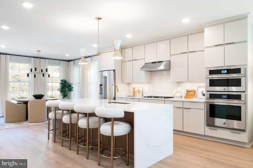 This two-level penthouse condo features an open and airy main level with a gourmet kitchen, light-filled dining room, pocket office, and spacious great room that flows seamlessly to the outdoor living space. The kitchen is complete with Ethereal Haze quartz countertops, waterfall island, Painted Jet cabinets, KitchenAid stainless steel appliances, and matte black hardware. Upstairs you'll find a luxe primary suite with two walk-in closets, two secondary bedrooms, and a full laundry room. Photos shown are of the Bellamy model.