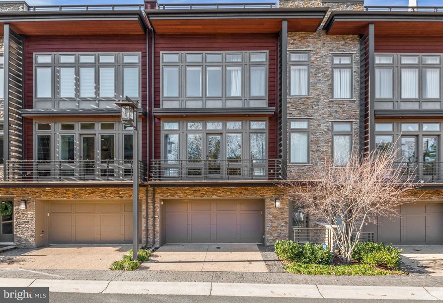 Luxurious rooftop elevator townhome in sought-after Little Falls Place with direct access to the Capital Crescent Trail!  Located one mile outside of Washington, DC  and just 7 minutes away from downtown Bethesda! 
This gorgeous 4 Level townhouse has a gourmet kitchen with top of the line appliances, stained shaker style cabinets and a glass tile backsplash, huge island and tons of storage, including an extra deep kitchen pantry . The great room is beautifully open to the kitchen with a remote-controlled gas fireplace, built-in shelves, and  floor to ceiling windows, you will also find the patio access here as well as a second half bathroom for your guests. On the other side of this level you will find a huge dining room and a  custom-built home office with frosted glass pocket doors and spacious built-ins.  Main level has remote-controlled blinds throughout.  Go up to find three spacious rooms, 2 full baths and laundry closet with stackable laundry machines. The main suite features two walk in closets, a large ensuite bathroom and a bump out.  The basement level offers a multi-functional room, that can be your gym, second office or guest room , a half bathroom is steps away from the garage door and the elevator, which reaches all levels! Finally, go up to the fourth level to find your rooftop oasis! Perfect for entertaining or just relaxing, this amazing outdoor space includes a hot tub,  an outdoor gas fireplace for chilly weather, gas grill hook up. entertainment center with a fridge, sink, dishwasher, TV and sound hookups plus storage that can be conveniently hidden behind a waterproof canvas roll up screen when you are not using it.  Don't miss the opportunity to live in this amazing home with tons of upgrades and amenities!!