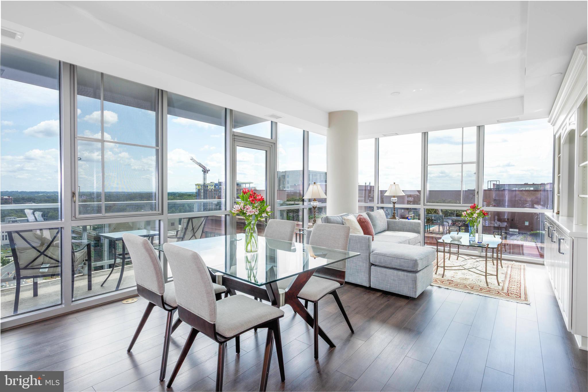 OPEN SUNDAY 8/24, 1-3PM!
EXPERIENCE LUXURY URBAN LIVING WITH UNPARALLELED VIEWS!
Welcome to elevated urban living at its finest—this stunning 2-bedroom, 2-bathroom, 1-parking, and 1-storage CORNER UNIT offers south- and southwest-facing panoramic views of downtown Bethesda, Washington DC, and Virginia. Enjoy breathtaking sunsets, dazzling fireworks, and uninterrupted vistas from every angle of the soaring floor-to-ceiling windows and 9- and 10-foot ceilings throughout! Perched high above the Canopy by Hilton Hotel in the vibrant Pike & Rose community, this modern 2018-built residence has been meticulously maintained by its original owner and presents a rare opportunity to own a premier unit in one of the area's most sought-after buildings.
The stylish entry at 930 Rose Avenue greets residents and guests with full concierge service and elegant lobby seating. On the 17th floor, a private foyer leads you past a coat closet, pantry, full-size front-loading washer and dryer, and a beautifully appointed hall bathroom. The secondary bedroom, ideal as a guest room or home office, is located just off the hall.
An expansive, open layout past the private hallway creates a sense of space and sophistication. At the heart of the home, the modern Euro-style kitchen is a chef’s dream, featuring Italian cabinetry, a quartz island with breakfast bar seating for three, and premium stainless steel appliances. The kitchen flows seamlessly into the sun-drenched living and dining area, where a custom-designed entertainment center and access to a private balcony provide the perfect setting for entertaining or relaxing, surrounded by unbeatable views. Solid panel doors, engineered wood floors, contemporary hardware, and deluxe custom roller shades complement the clean, polished design.
The primary suite is a true retreat, offering a large walk-in closet with beautiful custom built-ins, recessed lighting, and a spa-inspired en-suite bathroom complete with an oversized glass-enclosed shower, dual quartz vanities, illuminated LED mirror, and mirrored medicine cabinet.
Just steps from the vibrant energy of Pike & Rose, this condo provides the perfect balance of tranquility and convenience. Residents of 930 Rose enjoy exceptional amenities, including a secure resident’s garage, concierge services, and private elevators. The rooftop features soaring floor-to-ceiling windows, a sleek fitness center, beautiful lounge with a fireplace ideal for private parties and meetings, a billiards room, and an outdoor terrace with gas grills and expansive 360 views. Step outside the lobby to explore a wide range of dining options, high-end shops, retail stores, iPic movie theaters, and endless entertainment. Socialize over coffee and croissants at Sunday Morning Bakery, indulge in an ice cream at Baked Bear, an acai bowl from South Block, or enjoy a round of bowling at Pinstripes. With something for everyone, the Pike & Rose community is truly a vibrant hub for all ages. Conveniently located just minutes from Whole Foods, Giant, Strathmore Music Center, and the North Bethesda Metro Station (red line), this location offers unbeatable access to everything!