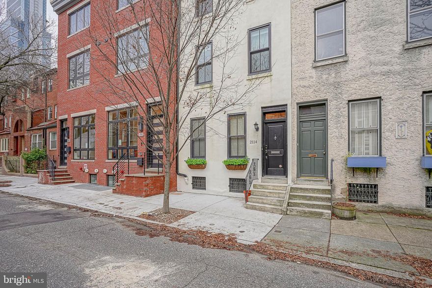 Located on a serene, tree-lined block within the Greenfield School Catchment, 2114 Cherry Street is an exceptional 4-bedroom residence in the heart of Logan Square. It boasts 2-car parking, 3 living rooms, a home gym space, an extra office room, and a spacious roof deck with sensational views of the cityscape. A charming, traditional vestibule entrance leads you past the formal parlor featuring 2 oversized front windows, rich hardwood flooring, a decorative fireplace with an ornate wooden mantle, and crown molding accenting the extra-tall ceilings. Continue onto the dining area with 2 convenient storage closets and a granite-topped butler cabinet. As you move on to the additional living space, take note of yet another storage closet under the eye-catching curved stairwell with a traditional banister. The completely updated kitchen receives an abundance of natural light from the south-facing glass sliding doors and extra-large window. The true Chef’s kitchen is outfitted with stainless steel appliances, extensive quartz countertops, and plenty of storage options, including a full wall of floor-to-ceiling custom cabinetry. The all-white kitchen is adorned with exposed beams, creating a truly one-of-a-kind setting. Beyond the kitchen is a bonus space currently configured as a spacious and fully functional home gym, complete with a mirrored wall and a soft mat floor. A separate laundry room with a raised washer/dryer, full laundry sink, and additional storage can be found here as well. Head upstairs to find a generously sized guest room with a step-in closet, in addition to two smaller children’s bedrooms that could be easily converted to a larger bedroom as needed. This floor is complete with a full guest bath. The third-floor primary suite features a vaulted ceiling with a skylight, an enormous walk-through closet, and a fully updated en-suite bath with a dual vanity and a spacious glass-doored shower. This floor has access to another bonus space that could be utilized as a home office or easily converted to an additional bedroom. The sun-drenched space features an exposed brick wall and access to a balcony with skyline views. Continue upstairs to find the private and expansive roof deck with jaw-dropping views of the city. Situated in the premier Logan Square neighborhood, this home offers easy access to all the delightful restaurants and cultural landmarks that make downtown living so desirable.