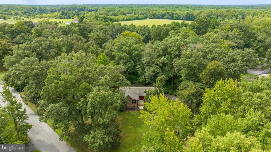 Nestled on over 1.38 acres,  in a tranquil and well-established community, this charming listing offers an idyllic lifestyle surrounded by mature trees. This all-brick rambler is poised to capture your heart with its timeless elegance and thoughtful layout. Boasting 4 spacious bedrooms, this home provides ample space for your family's comfort and privacy. The classic appeal of hardwood flooring adds a touch of warmth and character to the living spaces. With 2 full baths, mornings will be a breeze! The heart of this home is the generous eat-in kitchen, perfect for creating culinary delights while enjoying the scenic views beyond the windows. For more formal occasions, the separate dining room sets the stage for memorable gatherings.
The family room, adorned with a charming brick fireplace, invites cozy evenings by the fireside, creating a space for making cherished memories. A second fireplace graces the basement, which offers the exciting opportunity to customize and complete this space according to your vision, turning it into a reflection of your unique style and needs. Over the years, the owners have upgraded the electric panel, installed a septic system, replaced the hot water heater, roof-to include plywood (2016) amongst other maintenance items.
Positioned on the outskirts of Waldorf, you'll relish the peaceful ambiance while still being conveniently close to modern amenities. Whether it's shopping, dining, or educational institutions, everything you need is just a stone's throw away. Commuting is a breeze with excellent routes connecting you to DC, Virginia, and local military bases, making everyday travel a seamless experience.  Don't miss the chance to call this charming property your own . Property is being sold AS-IS.