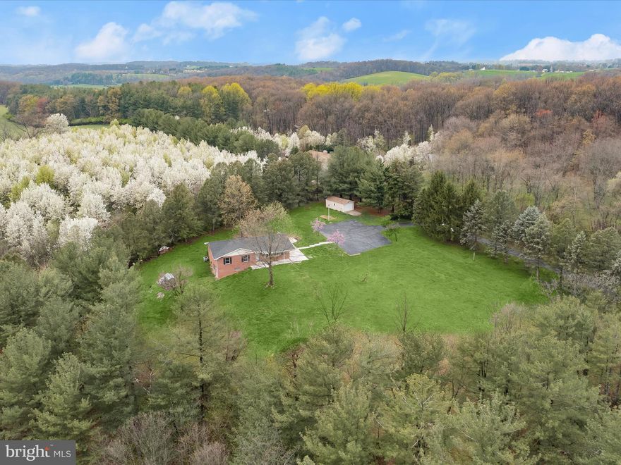 Welcome to 420 Leppo Road a sprawling rancher nestled on 6.09 picturesque acres, offering breathtaking views and serene country living. This light-filled home features an open concept floor plan, where the spacious living room is anchored by a charming bow window that frames the natural beauty outside. The eat-in kitchen is both functional and inviting, complete with abundant cabinetry, a center island with breakfast bar, pantry, wall oven, and a casual dining area that opens directly to the rear patio perfect for entertaining or relaxing. The main level includes a primary bedroom with an en-suite full bath, two additional bedrooms, a full hall bath, and a convenient laundry room. Downstairs, the expansive lower level offers endless possibilities, including the potential for an in-law suite with a private entrance, a possible second kitchen, cozy living room with wood stove, workshop, and ample storage space. A detached garage and extended driveway provide plenty of parking, and recent updates such as the roof and hot water heater add peace of mind. Don’t miss this rare opportunity to enjoy comfort, space, and stunning views all in one.  Some photos have been virtually staged.