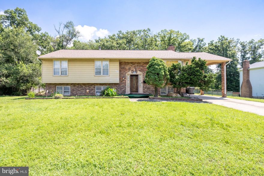 This terrific 4 bedroom, 3 full bath home nestled on a nice level .44 acre lot in a fabulous location delivers plenty of living space on 2 finished levels. A tailored brick and siding exterior, attached 1-car carport and concrete driveway, deck, patio, and fenced rear yard backing to trees create instant outdoor appeal. Inside, an open floor plan, hardwood flooring throughout, kitchen with upgraded appliances, updated hall bath, and spacious family room with fireplace and wet bar are just a few features that make this home so special. ****** An open foyer welcomes you home and ushers you upstairs into the light filled living room. The adjoining dining room features a shimmering chandelier and a French style door that open to the deck with steps descending to the patio and fenced grassy yard backing to trees, perfect for indoor and outdoor entertaining. The kitchen features an abundance of wood cabinetry and quality appliances including a glass cooktop with custom rangehood, built-in microwave and wall oven, and stainless steel refrigerator. The breakfast area features a large bay window and has an extra refrigerator. Hardwood flooring continues down the hall and into the primary bedroom boasting a lighted ceiling fan and private bath. Two additional bedrooms, each with hardwood flooring, share access to the updated hall bath featuring a dual sink vanity and jetted tub/shower combo. ******* The walk-out lower level family room has plenty of space for games, media, and relaxation and boasts a wet bar and a fireplace with woodstove insert set in a floor to ceiling brick accent wall. A 4th bedroom, den, and bonus room provide loads of versatile space to meet the demands of your lifestyle, while an additional full bath and laundry room complete the comfort and convenience of this great home. ****** All this conveniently located just minutes to an abundance of shopping, dining, and entertainment including all the National Harbor waterfront has to offer including The Capital Wheel, MGM, Tanger Outlets, and so much more. Commuters will love the easy access to I-495, 95, 295, Old Town Alexandria and DC!