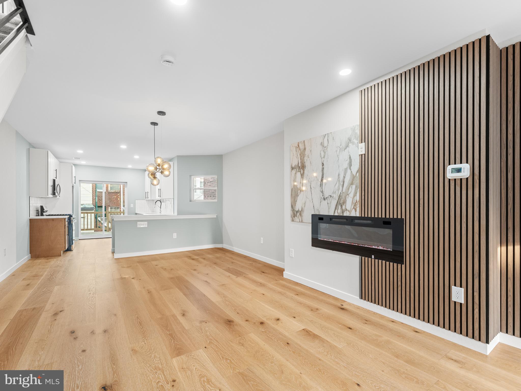 Introducing 7425 Andrews Avenue, a truly radiant gem nestled in Philadelphia's desirable West Oak Lane neighborhood. This 3-bedroom, 2.5-bath townhome has undergone a complete transformation, now ready to dazzle its new owner. Step inside and be greeted by gorgeous hardwood floors that flow seamlessly throughout the first level, leading you to a show-stopping accent wall. This contemporary masterpiece features a stunning paneled and tiled design, complete with an electric fireplace that adds an inviting ambiance to your living space. The heart of the home, a sleek galley-style kitchen, awaits. It boasts white and oak soft-close shaker cabinets offering ample storage, complemented by beautiful quartz countertops and a modern tiled backsplash. All-new stainless steel appliances complete this sophisticated culinary haven. Just off the kitchen, sliding glass doors open to your newly built private deck, perfect for seamless indoor-outdoor entertaining. Upstairs, discover a quaint master suite, offering a peaceful retreat with its own private master bath. Two additional bedrooms and a newly designed modern hall bath complete the second floor, providing comfort and style for everyone. The journey continues to the fully finished basement, featuring a convenient powder room and direct access to your garage. With all major systems updated, this home offers peace of mind and the luxury of modern living. Don't miss the opportunity to own this meticulously updated and move-in-ready West Oak Lane treasure!