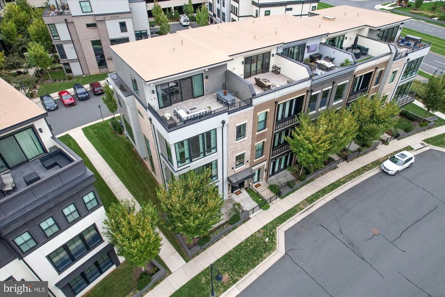Rarely available, a very special, luxury end-unit townhouse by Miller & Smith with a private elevator facing One Loudoun's Central Park.  This magnificent home is simply stunning with upgrades and designer touches throughout.  The chef's kitchen is magazine worthy with Wolf and Sub-Zero appliances including a custom wine refrigerator, built-in coffee/espresso machine and a 13' island with quartz countertops with a waterfall edge.  Noteworthy architectural details are sure to impress with floor to ceiling windows, high-end cabinetry and built-ins, 10' high ceilings, Lutron motorized shades, wide-plank engineered wood floors, upgraded railings, designer lighting and multiple outdoor living spaces. The 1LX floor plan is ideal for living and entertaining and features 4 bedrooms, each with a professionally organized closet and an en-suite bath as well as 2 powder rooms and a main level office.  The primary suite offers views of the park and boasts a spa-like primary bath with radiant heat stone floors, a walk-in shower, separate soaking tub, electric mirror and quartz counter tops.  Retreat to the upper level loft and you will be amazed by the spectacular rooftop terrace with panoramic views with wood tile flooring, a gas fire pit and motorized awning.  The spacious and light-filled loft area is an welcome retreat with built-in cabinets and a beverage refrigerator, ideal for a home office or for entertaining.  There is ample storage throughout with the custom cabinets in the laundry room and in the mudroom, as well as additional wall mount storage cabinets in the garage, complete with EV charging and an epoxy floor.

One Loudoun is a unique place of sophisticated culture and urban-inspired architecture located in the heart of Loudoun County, VA at Rt. 7 and Loudoun County Parkway.  Comprising 358 acres, the community integrates a town atmosphere with great neighborhoods and an exciting downtown of retail, dining and entertainment.  One Loudoun Neighborhood Association amenities include a resort-style Clubhouse, outdoor pool, tennis courts, pickle ball courts, half-court basketball, sand volleyball, meeting rooms, 3 playgrounds, and a "Central Park" which includes The Barn at One Loudoun, an amphitheater and barn venue that hosts community social events.  Stroll along the beautifully designed streetscapes to visit your favorite boutiques, dine at a wide variety of restaurants and bars, or enjoy a community event on the Downtown Plaza.