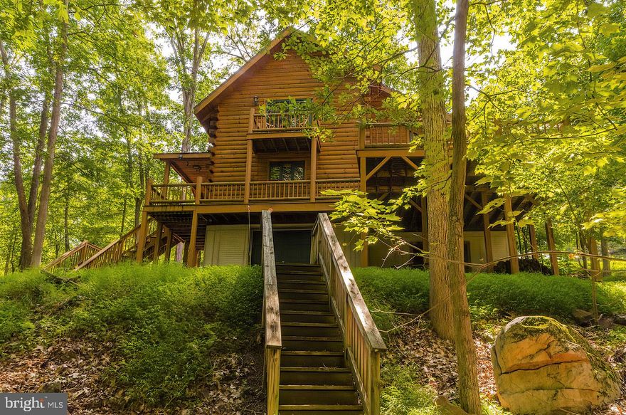 Beautiful log home situated on more than 2 acres in the gated wooded mountain retreat of Somerset in Paw Paw, WV. This spacious two-bedroom open-concept loft-style home boasts lots of natural light with more than 1,100  square feet and expansive deck perfect for entertaining. Home features large two-story living room with wood burning stove, beautiful hardwood floors and solid wood cabinetry. Handsome loft master suite has plenty of space for sitting/TV area. Watch the beautiful WV starry night skies or enjoy your morning coffee from the master balcony. Unfinished walk-out basement includes attached 1-car garage. This tastefully decorated beauty comes fully furnished! Additional lumber in basement is available to complete space with log finish. This home is part of a family-friendly clothing optional community. Annual memberships are available for access to adjacent Avalon Resort, which features vacation condos, lodge, an aquatics center, as well as camping. Just two hours from DC area, 40 minutes from fabulous shopping and restaurants in Winchester, VA, and 30 minutes to the historic spas of Berkeley Springs, WV. Come check out this unique property on Wild Apple Lane and find out precisely why the owners dubbed it "Almost Heaven."