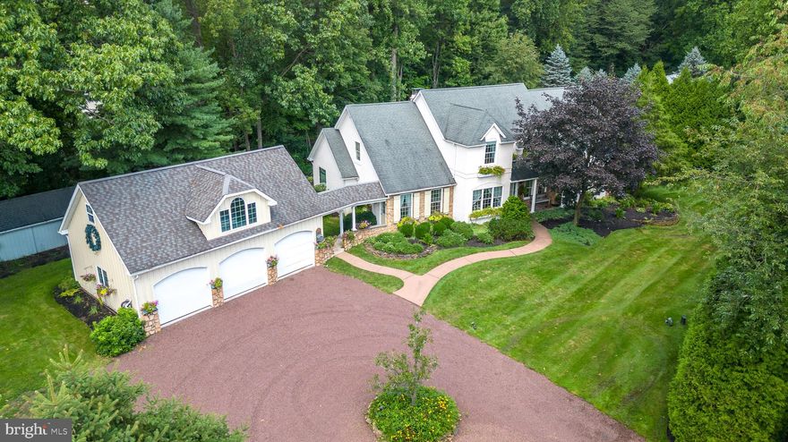 A picturesque setting for this custom built 5 bedroom, 3 full bath home. Set back from the road, the property is surrounded by mature trees and backs to township preserved lands with trails to enjoy. The outside is adorned with gorgeous landscape, including manicured garden beds and garden irrigation system. A stunning rear yard complete with an inground pool, new heater, a waterfall and hot tub. Covered paver patio and a Pergola add great space for outdoor enjoyment. A 3 car garage includes a finished second floor and huge shed ideal for the gardening tools and outdoor toys, and a lush open yet private yard. Inside you will find a spacious main level with open floor plan, hardwood floors, high ceilings and many windows to brighten the space. The inviting two story foyer has views of the second floor loft. The great room, boasts a vaulted ceiling, floor to ceiling stone fireplace, and oversized windows. The great room flows to the breakfast room and kitchen including and abundance of cabinetry and counter top space. A center island is perfect for meal prep with space for the stools. Bosch appliances and gas Wolfe range add to your experience. A breakfast area allows for the large table for enjoying your everyday meals. Off the breakfast room you'll find the living room creating a place for relaxing and entertaining. A formal dining room is also accessible from this area for those special meals. There is a first floor primary bedroom with a huge walk-in closet and a full bath with soaking whirlpool tub, a separate stall shower, two pedestal sinks and linen closet. Completing the main floor is a second bedroom or office, and full hall bath, a separate laundry room with access to the finished basement and the breezeway out to the 3 car garage. The second level is equally impressive. The sitting area has a cozy gas fireplace and two balconies overlooking the great room and entryway. This level includes three spacious bedrooms, each with ample closet space, and full hall bath to service this floor. Additional living space will be enjoyed in the expansive basement with a bilco walkout. There is an abundance  of space for entertaining, a family room, billiard room, and exercise area as well as a workshop. There is additional storage and a utility room. Convenient location for Doylestown and New Hope, serviced by Central Bucks Schools. This meticulously maintained property has a generator and has had pre-listing inspections to put your mind at ease!!