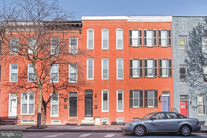 This extra-wide row home blends historic character, modern comfort, and unique features that set it apart from any other row home you’ve likely seen. As you enter, you'll notice the hardwood floors throughout the main level, a spacious living room with a charming fireplace, and a generously sized closet for coats and additional storage. Transitioning into the dining area, you’re immediately struck by the stunning two-story architectural staircase, which allows natural light from the upper floors to cascade down—making this space versatile and bright. Thanks to the high ceilings, ample side windows, and that incredible staircase, this home feels anything but typical for Baltimore row homes. Next, you'll find the updated kitchen featuring stainless steel appliances—including a gas range—vaulted ceilings, recessed lighting, and plenty of cabinet space. Step out through the rear entrance to access your two private parking pads. Bonus: this home may qualify for an assumable VA mortgage with a 3% interest rate—a rare and valuable opportunity! Upstairs on the second floor, you’ll find the first of two front-facing primary bedrooms, a beautifully renovated full bathroom, and a versatile second room—perfect for a home office or cozy guest space (note: no closet). From this room, step through sliding glass doors onto the rooftop deck, constructed with low-maintenance composite decking and railings—durable, easy to clean, and built to last. Continue up to the third floor where you’ll find a full laundry room with side-by-side washer and dryer and access to a rear balcony. Toward the front of the home is a bonus flex space, ideal for another office or hobby area, and finally, the second front-facing primary bedroom complete with two closets and a full bath located just outside the bedroom space.Throughout the home, enjoy fresh paint, and thoughtful updates.  The large basement offers ample storage and exciting potential for the future. Along with access to the homes mechanical systems, central gas heat, air conditioning, and water heater.Located on one of the best residential streets, you're just one block from Cross Street Market and a five-minute walk to historic Federal Hill—perfect for soaking in panoramic views of the Inner Harbor. Don’t miss the Fourth of July fireworks!