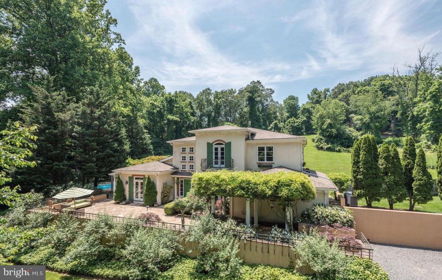 Welcome to a one-of-a-kind Tuscan-inspired estate nestled on a private 5-acre retreat in the heart of McLean.  This custom-built home, offering over 6600 sq/ft of living, seamlessly blends classic European charm with modern luxury, offering an unparalleled lifestyle of elegance, comfort, and seclusion

As you drive through the private, gated entrance, a long picturesque driveway winds through lush landscaping, setting the tone for this exceptional property. The gracious entrance welcomes you with a striking green door, high ceilings, and abundant natural light. Inside, the great room is a showstopper, featuring sky-high ceilings and a stately marble fireplace that creates a warm yet sophisticated ambiance. French doors throughout the home invite natural light and provide seamless access to the stunning outdoor spaces.

The gourmet kitchen is a chef’s dream, boasting handcrafted wood cabinetry, granite countertops, high-end appliances, and a large center island perfect for entertaining. A butler’s pantry with elegant glass cabinetry and a beverage fridge ensures convenience and style, while the formal dining room, adorned with a dramatic chandelier and natural wood finishes, opens to serene outdoor terraces, making it the perfect setting for gatherings.

The main-level primary suite is a private sanctuary, complete with a spa-like en-suite bath, a custom walk-in closet, and direct access to a private terrace. Additional bedrooms feature elegant chandeliers and access to balconies with breathtaking views of the lush surroundings. The lower level offers a cozy a billiards table, recreation room and a fifth bedroom perfect for leisure. 

Stepping outside, you’ll find a resort-style oasis designed for relaxation and enjoyment. The estate boasts an expansive outdoor pool surrounded by an elegant stone patio and wisteria-covered pergolas, offering a tranquil and picturesque setting. A sun-drenched terrace provides the perfect backdrop for al fresco dining, while the beautifully maintained pickleball court cater to an active lifestyle. Meandering pathways lead to peaceful garden spaces, inviting moments of serenity and reflection.

This breathtaking villa is ideally situated in a prestigious enclave of McLean, offering the ultimate privacy while maintaining proximity to the area’s finest shopping, dining, and cultural experiences. Just minutes from Tysons Corner, Great Falls Park, and major commuting routes to Washington, D.C., this home provides a perfect balance of seclusion and accessibility. More than just a residence, this estate is a sanctuary that embodies elegance and resort-style living.Don’t miss this rare opportunity to own a slice of Tuscany in Northern Virginia.