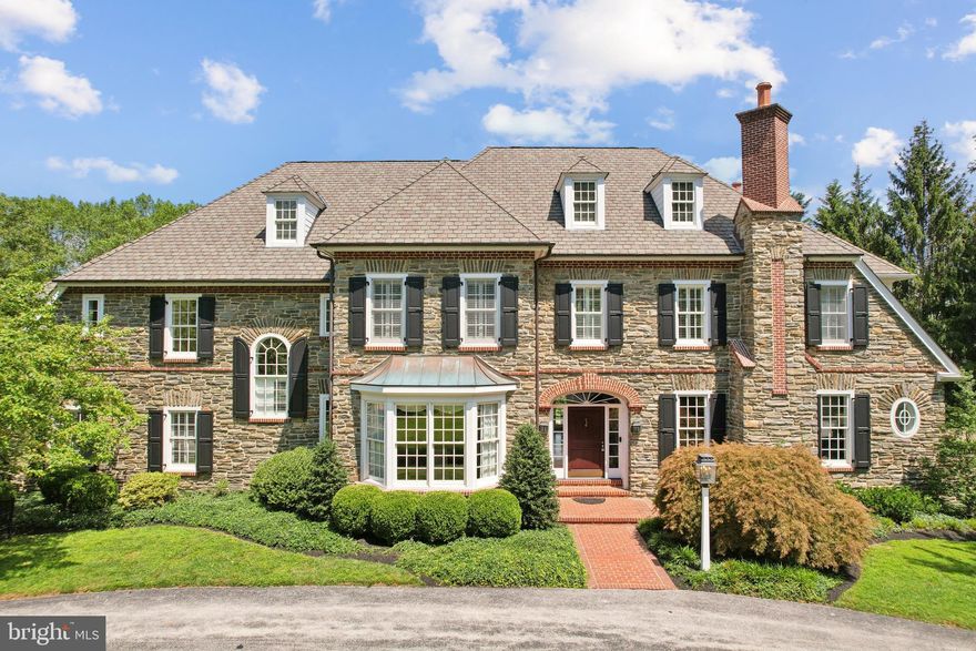 Presenting 1330 Fenimore Lane, an undeniably impressive estate home in the prestigious Gladwyne community, offering 5 bedrooms, 5 full & 2 half bathrooms, and 7,824 square feet of elegant living space.  The jewel of Gladwyne’s premier neighborhood, this former model home reflects the unmatched vision of Visich Architects, beautifully executed in collaboration with Pohlig Builders.
From the wide, welcoming foyer, you’re immediately drawn into the formal living and dining rooms—each offering timeless architectural details and natural light that elevate both everyday meals and special gatherings.  The heart of the home—the chef’s kitchen—is a masterwork of design, featuring premium built-in appliances, stone countertops, and custom cabinetry that flows easily into the open-concept family room—perfect for both everyday comfort and entertaining.   Study in your handsomely paneled home office, enjoy wellness at your private gym & sauna, and entertain effortlessly from the expansive finished lower level. The finished basement may became your favorite rainy-day escape or place for game nights, movie marathons, and birthday parties, with space for everyone to spread out and be together.  A wine cellar and well appointed wet-bar, a private office, as well as multiple storage areas round out the lower level.  Enjoy the convenience of both lower-level and second-floor laundry.   Each of the five spacious bedrooms is a personal retreat with en-suite baths and luxurious finishes. The convenience of both a 2-car attached garage and 2 car detached, offer generous room for everyones toys.   Outside, a professionally designed hardscape patio with built-in grill offers an ideal setting for intimate dinners or grand celebrations. Gather under the stars for the evening wind down with stories and s’mores.   Tucked into one of the most coveted neighborhoods in charming Gladwyne, with private access to Kenealy Nature Park and the Bridlewild Trail, this residence pairs privacy with proximity to both nature and the main commuting routes.  This is a rare opportunity to own a standout home in one of Gladwyne’s most desirable settings, known for privacy, prestige, and pastoral beauty.