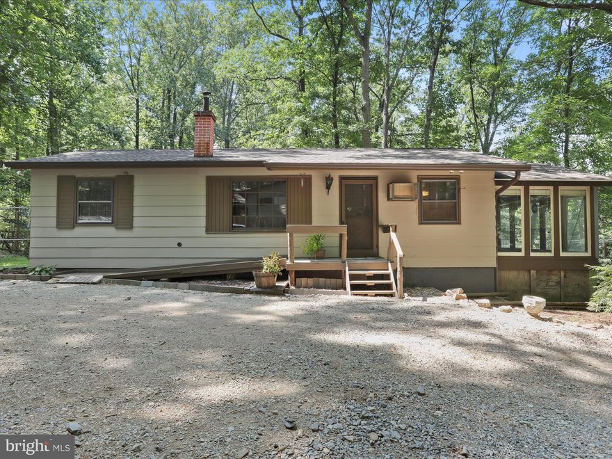 Discover the charm of this delightful ranch-style home nestled in the serene community of Shannondale. With 800 sq ft of thoughtfully designed space, this 2-bedroom, 1-bathroom residence boasts a cozy combination dining/living area, perfect for entertaining or relaxing. Enjoy the warmth of a wood stove and the comfort of the ceiling fan. Step outside to a picturesque half-acre lot, where nature meets tranquility. The property features lush landscaping, a gently sloping terrain, and a soothing creek that runs through the front yard, creating a peaceful retreat. A shed provides ample storage for your outdoor gear. Modern conveniences include an electric oven/range, refrigerator, water treatment system, and new flooring throughout ensuring your home is both functional and efficient. New roof installed July 2025.  With a gravel driveway accommodating up to four vehicles and exterior cameras for added security, this home is designed for comfort and peace of mind. Close to community clubhouse and lake. Embrace the lifestyle you've always wanted in this enchanting setting!