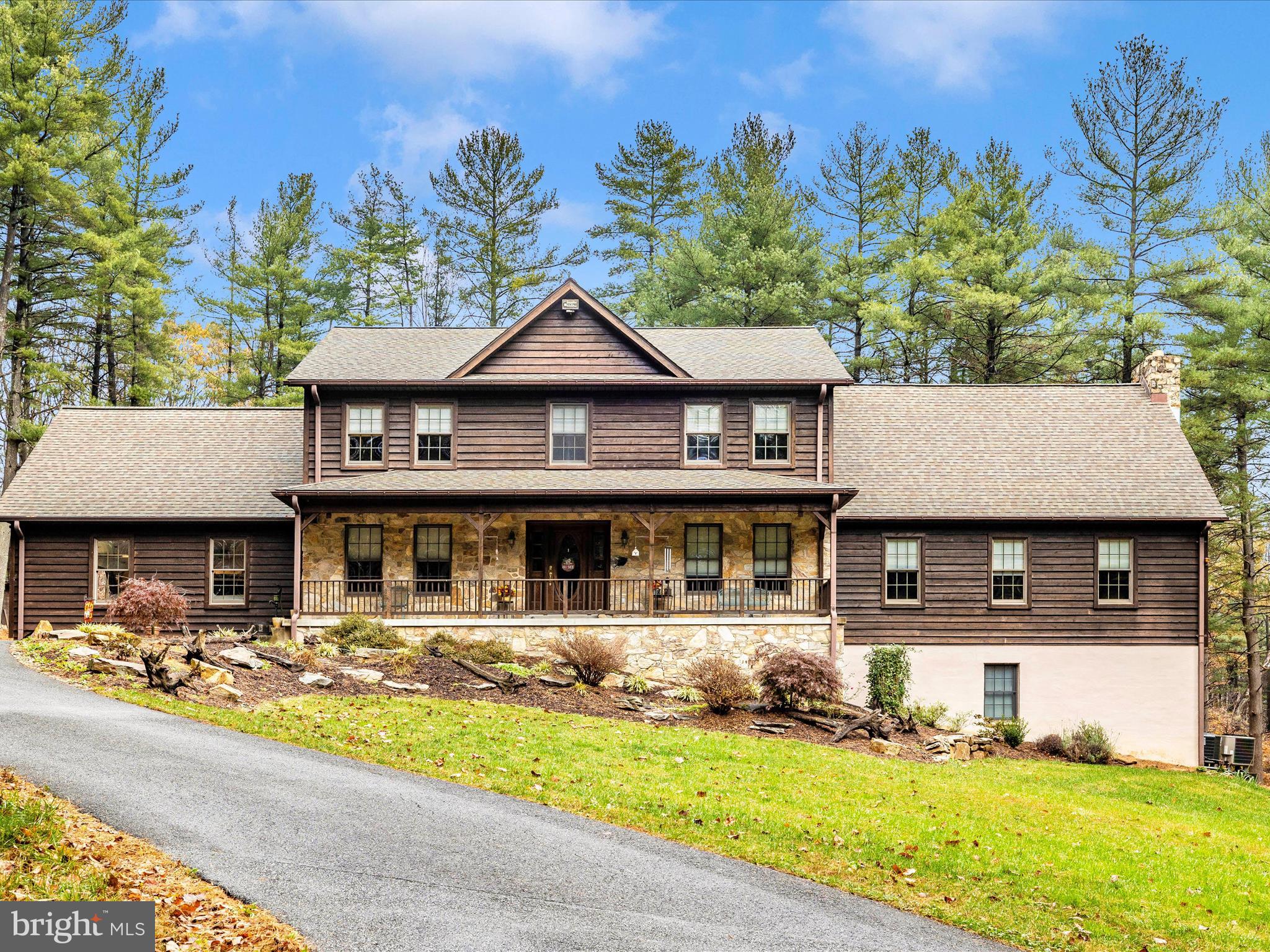 Welcome to a beautiful home almost 6 acres in the woods beside Mar Lu Ridge. This home is ready to move in with a great deal of personal care and amenities. Your first view is the full 800 ft asphalt driveway to a lovely Stone and Log home. The front entry has a lovely sitting porch to a front foyer that leads to a Red Oak stairway with custom front door. 2 Car garage has an entryway with a custom hall tree organizer. Large laundry/storage room which leads into Lovely Kitchen with Custom Cherry Shaker Style Cabinets with Oak wainscotting. Kitchen has a center island with a built in Beverage cooler and a Kitchen Aid station. The eat-in kitchen area has room for a table and chairs with a built-in bar w/TV. The first floor has Hardwood White Oak Flooring throughout. Newly remodeled handicap accessible 1st floor Bathroom with walk in shower and a bidet with custom cabinets. Built-in cabinets with electric in the dining room too. Many unique features.
Past the Kitchen is a large 25 x 30 Great Room with Cathedral Ceiling, vaulted 25 ft. ceiling with a loft (10 x 25) over head from the Master Bedroom. Build-in desk w/workstation in Walnut wood in the Great Room with a Large 16 ft Custom Mantel over Wood stove and Stone Wood Box areas. Large Deck 16 x 52 that is two level with entry from Kitchen and Great Room. Siding is Hemlock Wood. Central Vac, Silent Night Fire Alarm, three heat pumps, and roof are only 10 years old with 30-year shingles.
The upstairs Master Bedroom has a lovely Bathroom with all modern upgrades, walking shower w/jets, garden tub – no jets, two countertop sinks and a built-in vanity. Master Bedroom has French Doors to small Balcony Deck to sit and out and watch nature. A doorway to the Loft over the great room. Carpet throughout all three bedrooms. One Bedroom has a built-in Craft station or desk area.
Whole House Brand New built-in Generator 26 KW with three propane tanks under deck. The walk out Basement is unfinished but ready for your distinctive touch. Large Out Building that is climate controlled and has a 2nd level for more storage. Attached is a covered car port for either a truck or Equipment. Circle Asphalt Driveway to Out Building for easy care of the property. Outside HD lighting around the house and the Out Building too. The second smaller shed is from Mar Lu Ridge Camp from 1962 and can be used for storage or décor. Updated just NOW! New Well Pump Installed.
This home is a must see to view all the custom cabinets to the woodworking and special amenities throughout the property. NOTE: Basement entrance currently from garage, because of being a workshop. However, potential to add Interior Stairway entrance to basement available inside under main staircase which is already with a rough-in doorway. Great for a new finished basement!!