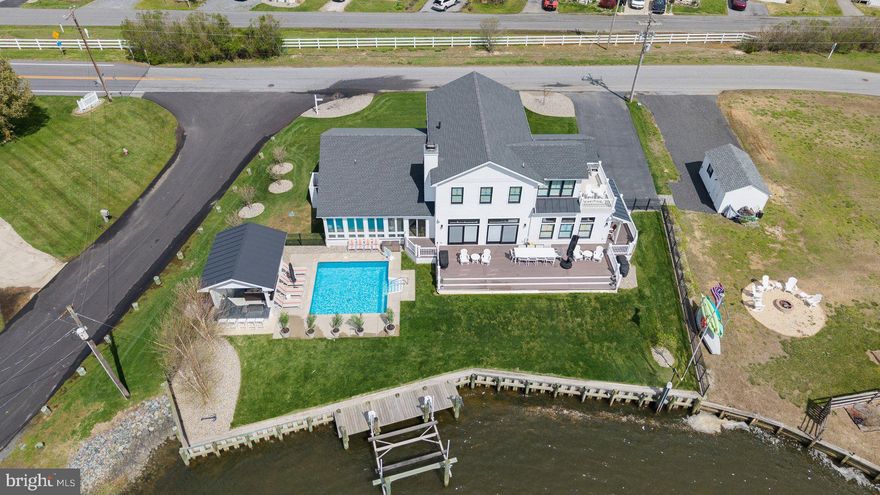 Welcome to “The Boathouse” – where waterfront resort living meets timeless elegance on the Rehoboth Bay.  Built in 2021 with top-tier finishes and thoughtful custom details, this exceptional home invites you to embrace serene water views, breathtaking sunsets, and the ultimate boater’s lifestyle. Designed for both relaxation and entertaining, the home features multiple living areas, including a cozy living room with a wood-burning fireplace, a lively party room, and a stunning four-season room with seamless access to the pool and outdoor entertaining spaces. Step outside to your private oasis, complete with a heated saltwater pool, pool house featuring a leathered granite bar, lounge area, gas fireplace, premium Lynk grill, lush lawn, and a private boat slip. Inside, you'll find two luxurious primary suites—one on the first floor, and an expansive second-level suite with a private sitting room and sundeck overlooking the water. Reclaimed hardwood floors, custom built-ins, and shiplap details add warmth and character throughout, while a full-service bar with accordion windows connects the indoors to the outdoor bar seating. The main living areas are enhanced by reclaimed hardwood floors, shiplap accents, and custom built-ins, including a beautifully crafted storage wall built under the stairs. The chef’s kitchen is equally impressive, outfitted with GE Monogram Professional Series appliances, quartzite countertops, and a spacious butler’s pantry with a convenient laundry chute.
No expense has been spared and no detail overlooked—this is coastal living at its finest.
Don’t miss the special features page.