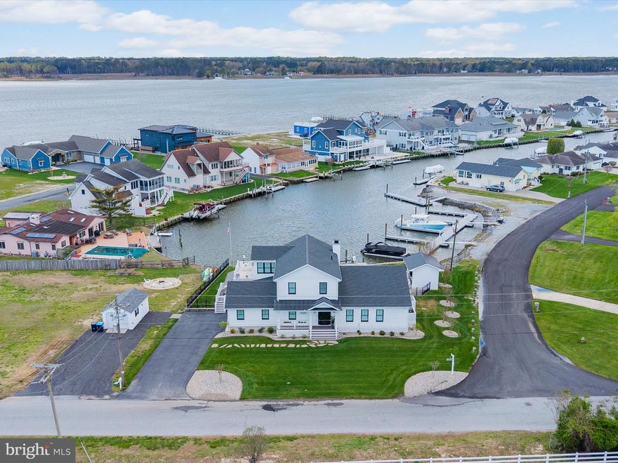 Welcome to “The Boathouse” – where waterfront resort living meets timeless elegance on the Rehoboth Bay.  Built in 2021 with top-tier finishes and thoughtful custom details, this exceptional home invites you to embrace serene water views, breathtaking sunsets, and the ultimate boater’s lifestyle. Designed for both relaxation and entertaining, the home features multiple living areas, including a cozy living room with a wood-burning fireplace, a lively party room, and a stunning four-season room with seamless access to the pool and outdoor entertaining spaces. Step outside to your private oasis, complete with a heated saltwater pool, pool house featuring a leathered granite bar, lounge area, gas fireplace, premium Lynk grill, lush lawn, and a private boat slip. Inside, you'll find two luxurious primary suites—one on the first floor, and an expansive second-level suite with a private sitting room and sundeck overlooking the water. Reclaimed hardwood floors, custom built-ins, and shiplap details add warmth and character throughout, while a full-service bar with accordion windows connects the indoors to the outdoor bar seating. The main living areas are enhanced by reclaimed hardwood floors, shiplap accents, and custom built-ins, including a beautifully crafted storage wall built under the stairs. The chef’s kitchen is equally impressive, outfitted with GE Monogram Professional Series appliances, quartzite countertops, and a spacious butler’s pantry with a convenient laundry chute.
No expense has been spared and no detail overlooked—this is coastal living at its finest.
Don’t miss the special features page.