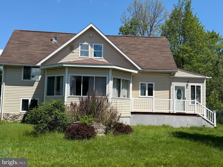 Welcome to this one-of-a-kind Cape Cod home in Arrowhead Lake, set on a flat lot with a peaceful lake view. This multi-level, two-bedroom, two-bath home is immaculately maintained, filled with natural light, and truly move-in ready. The lower level offers flexible living space with a washer, utility sink, mudroom, and room for a game or recreation area, along with the convenience of entering or exiting the home from this level. The front entrance welcomes you into a bright three-season room that leads into the main living area, where an updated kitchen features white appliances, an electric range, accented countertops, and hand-crafted inlaid tile flooring with a striking tree motif that flows from the front door into the kitchen. The kitchen opens comfortably to the living room, highlighted by hardwood floors, custom cabinetry, and a cozy wood-burning stove. A second custom inlaid tile motif extends from the wood-burning stove toward the staircase leading to the lower level, adding another layer of artistic detail. A sunroom/den with windows all around provides additional living space, while custom iron hinges, handles, and metal railings featuring artistic tree designs showcase the exceptional craftsmanship found throughout the home. One bedroom is located on the second level, with the upper-level bedroom offering knotty pine ceilings, natural tree limb posts and railings, and additional custom metal accents, creating a truly unique retreat. Complete with a deck, garage, electric baseboard heat, and lake views, this home blends comfort, creativity, and character—ideal as a full-time residence or a relaxing getaway.