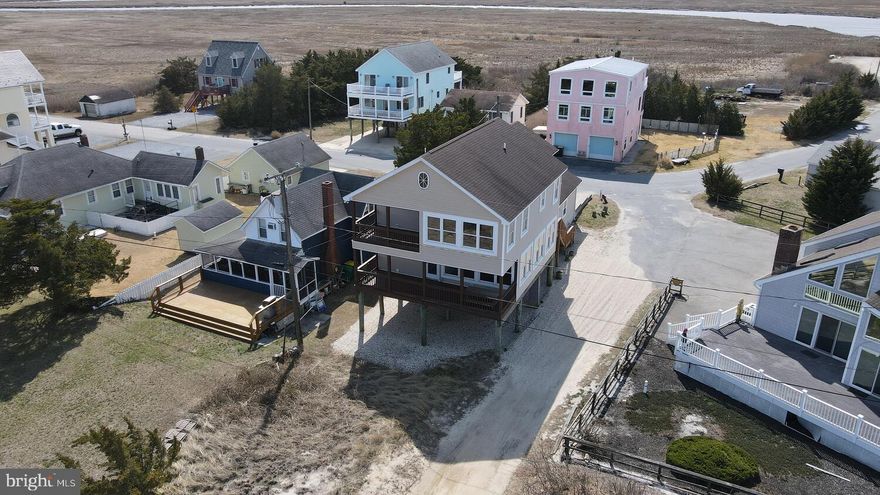 Don't miss out on this beautiful bay-front home, which offers water views and sandy beaches. Featuring 3 spacious bedrooms, a bunk room, and 2½ baths, this property provides plenty of space for family and guests.  Upon entering the home, you are welcomed by a large foyer with a convenient coat closet and powder room. The kitchen comes fully equipped with appliances, a breakfast bar with stools, and a dining table that comfortably seats several people.  The expansive great room is the heart of the home, complete with a pellet stove to keep things cozy on cool evenings. Adjacent to the great room is a dining and game area overlooking the large porch with breathtaking bay views. The porch includes a picnic table and ample seating, making it the perfect place to relax and watch boats travel along the bay and into the Murderkill River.  Upstairs, the primary bedroom offers stunning bay views, a private bathroom, a large walk-in closet, and access to a private deck just outside the door—perfect for morning coffee or sunset relaxation. Bedroom two features a generous closet, while the bunk room is ideal for guests or kids.  The nearby hall bathroom includes a linen closet for added storage and the additional large bedroom provides space for multiple beds if needed.  Additional features also include a Laundry/utility room with cabinets and a utility sink, a 2-car garage with pull-down attic storage, and covered space under the home perfect for shaded gatherings, plus an outdoor shower to rinse off after a day at the beach.  Residents also enjoy access to a private beach reserved exclusively for homeowners of South Bowers, offering peaceful coastal living with incredible views and easy water access.  This property also presents an excellent opportunity for an Airbnb or vacation rental investment. Its close proximity to the DE Turf Sports Complex makes it especially appealing for visiting families and sports teams looking for a convenient, peaceful bay-front setting while still being just a short drive from the tournaments and events.  This home will not last long so schedule your tour today!