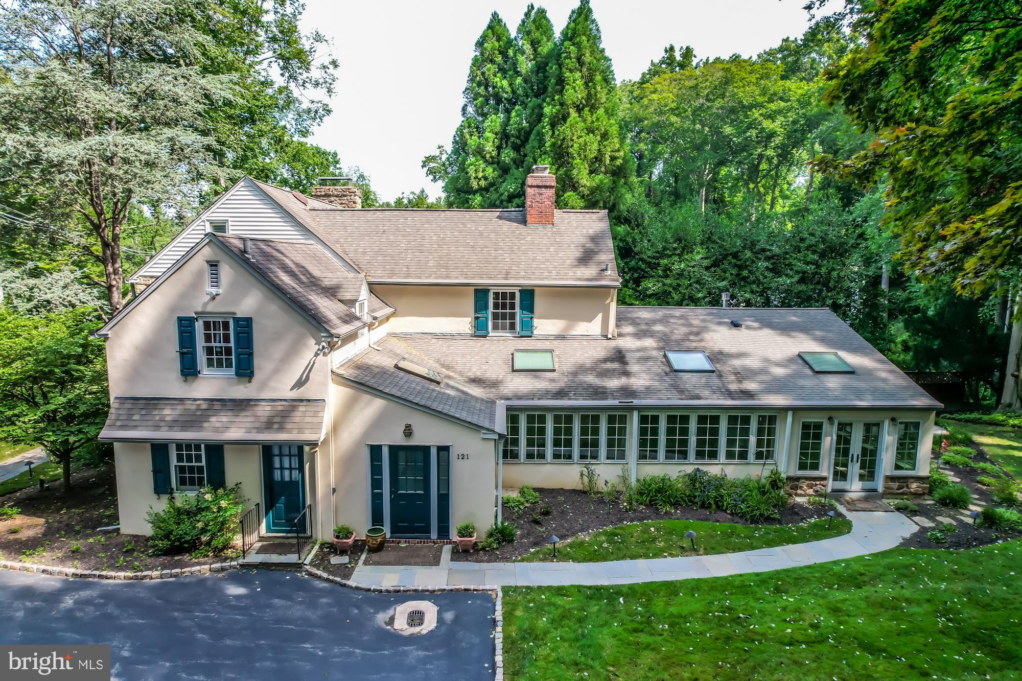 Welcome to 121 Gypsy Lane, a stunning colonial home with a separate detached in-law suite. Nestled on a beautifully landscaped 0.70-acre lot with mature trees, natural stone cliff in the back, and a peaceful Koi pond, this property exudes charm, elegance, and luxury. The main house offers nearly 5,000 square feet of finished living space, including 4 bedrooms and 4.5 bathrooms (three full bathrooms upstairs and one and a half on the main floor). As you step into the foyer, you'll be greeted by beautiful pine floors and exquisite custom mill work that add a unique character to the home. To the left of the foyer, the grand living room features custom mill work, built-in cabinetry with hand-blown glass doors, built-in shelving, large deep sill windows that flood the room with natural light, and an over sized gas fireplace. The dining room, with a full-size bay window overlooking the Koi pond, boasts a large gas fireplace and windows to the family room. A swinging door leads to a wet bar, which opens into the kitchen with Brazilian cherry laid in a herringbone pattern, a wall of windows, and a custom-built refrigerator. Adjacent to the kitchen is a laundry room with built-in custom cabinetry. Stunning glass French doors open to a Four Seasons Sun room with custom natural stone tile floors, a built-in fireplace, and access to the backyard. The family room, adjacent to the kitchen, is bathed in natural light from a wall of windows. The mudroom provides access from the driveway to the family room. Also on the main floor is a separate entrance to a spacious bedroom with a full bathroom and a large closet. Upstairs, the expansive primary bedroom features a grand gas fireplace flanked by two custom-built closets. The en suite bathroom includes built-in custom cabinetry. Two additional spacious bedrooms, each with its own full bathroom, a walk in closet, complete the upper level. The finished basement offers a wall of custom-built shelving and cabinetry for additional living space. Outside, follow the paver stairs with iron railing to the detached living space. This separate suite includes two sliding doors, a small kitchen, a bedroom with a full bathroom, and a living room with a wood-burning stove. Sliding glass doors lead to a deck, allowing guests to enjoy the serene natural surroundings.